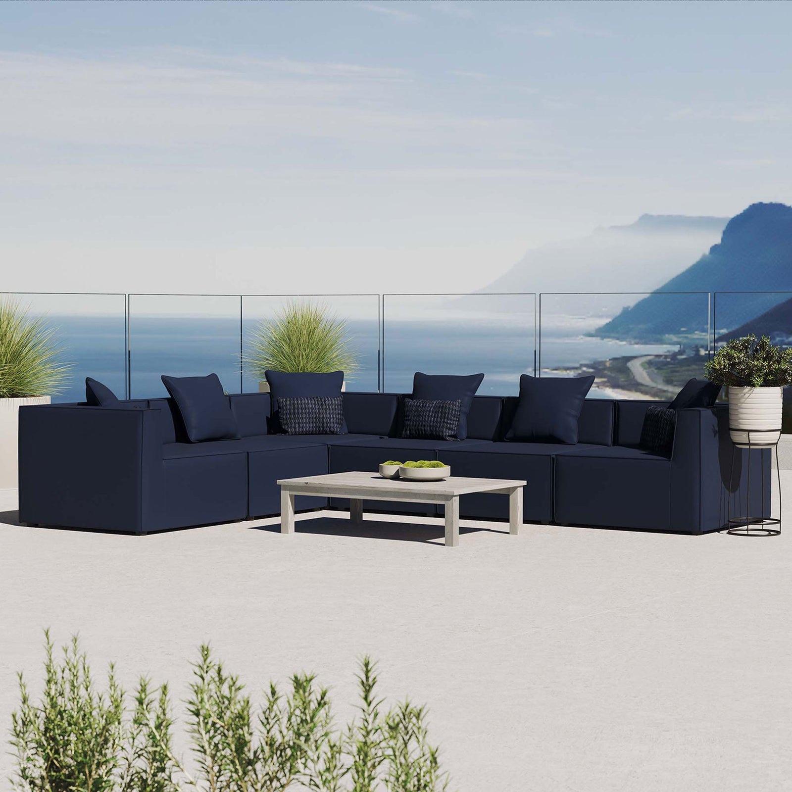 Navy outdoor sectional sofa styled on a balcony with ocean view and surrounding greenery || EEI-4385-NAV || front_angle_room