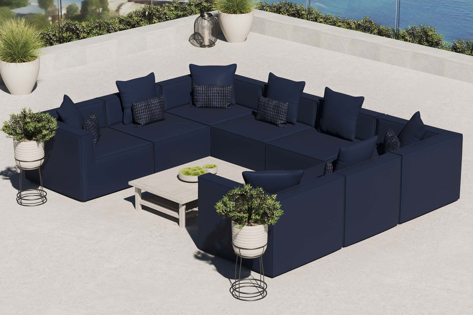 Navy Saybrook 8-piece outdoor sectional arranged on a sunny terrace with coordinating accent tables. || EEI-4388-NAV || front_angle_room