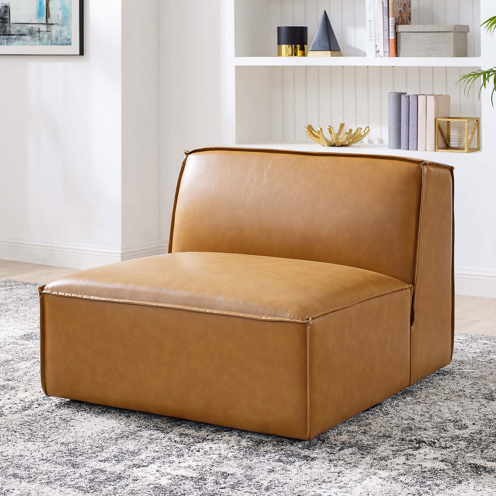 Versatile armless chair elevates living spaces with tan vegan leather and inviting, lounge-ready comfort. || EEI-4495-TAN || front_angle_room