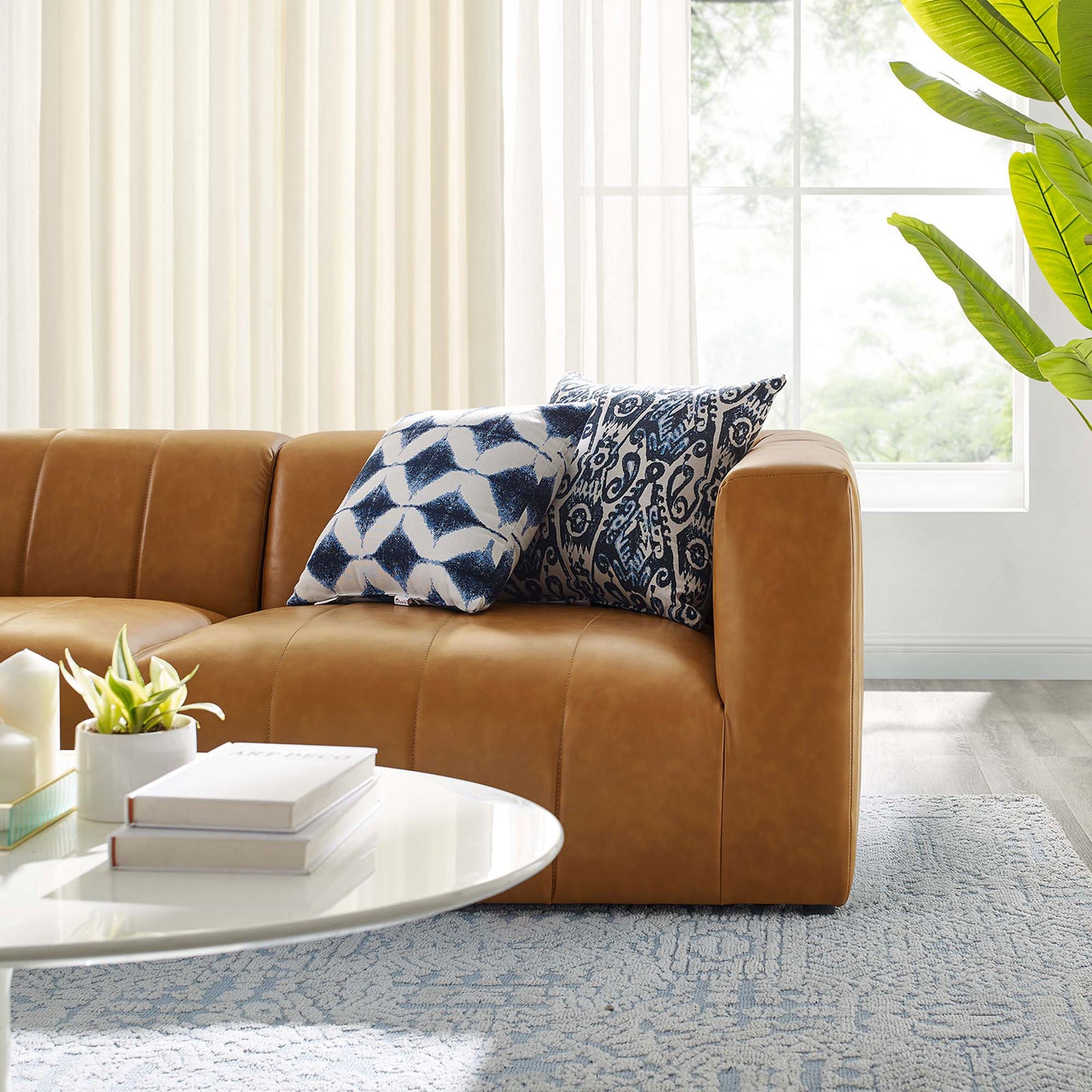 Tan vegan leather loveseat corner accented with patterned throw pillows in a modern living room || EEI-4513-TAN || detail_room