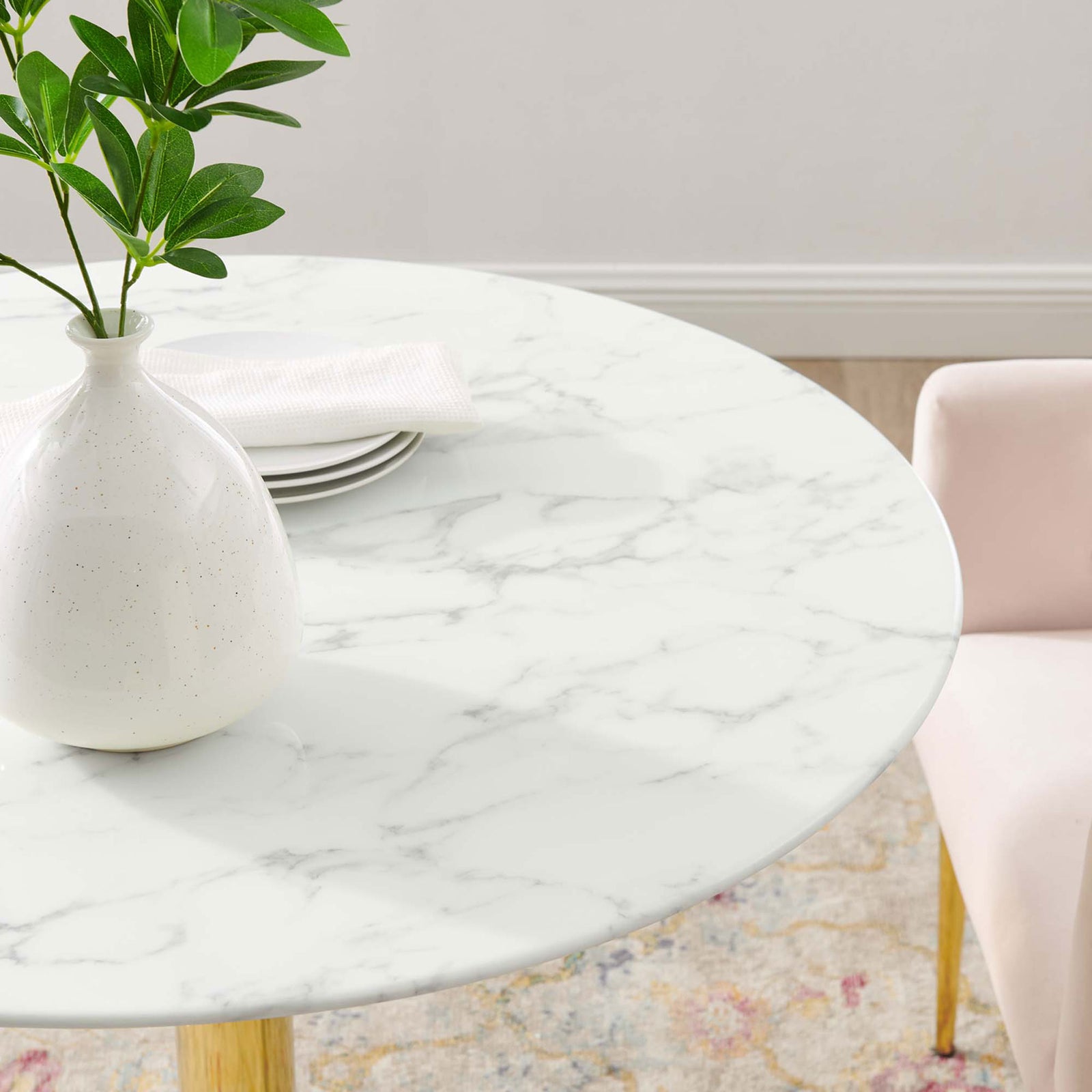 Smooth marble-look tabletop styled with vase, plates, and soft seating accents || EEI-4549-GLD-WHI || detail_room