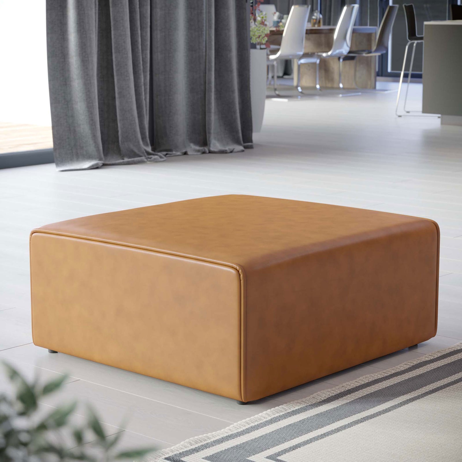Mingle tan vegan leather ottoman centered in a contemporary living room with sleek floors and draped curtains || EEI-4624-TAN || front_angle_room