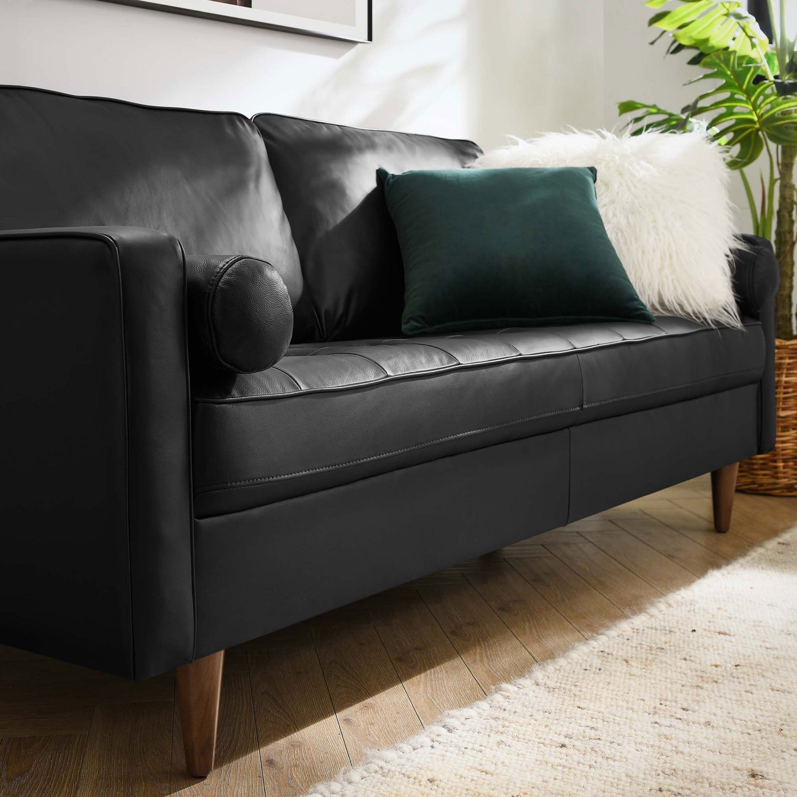 Plush black leather seat tufting, round bolster pillow, and soft throw cushions create an inviting Valour sofa spot. || EEI-4633-BLK || detail_room