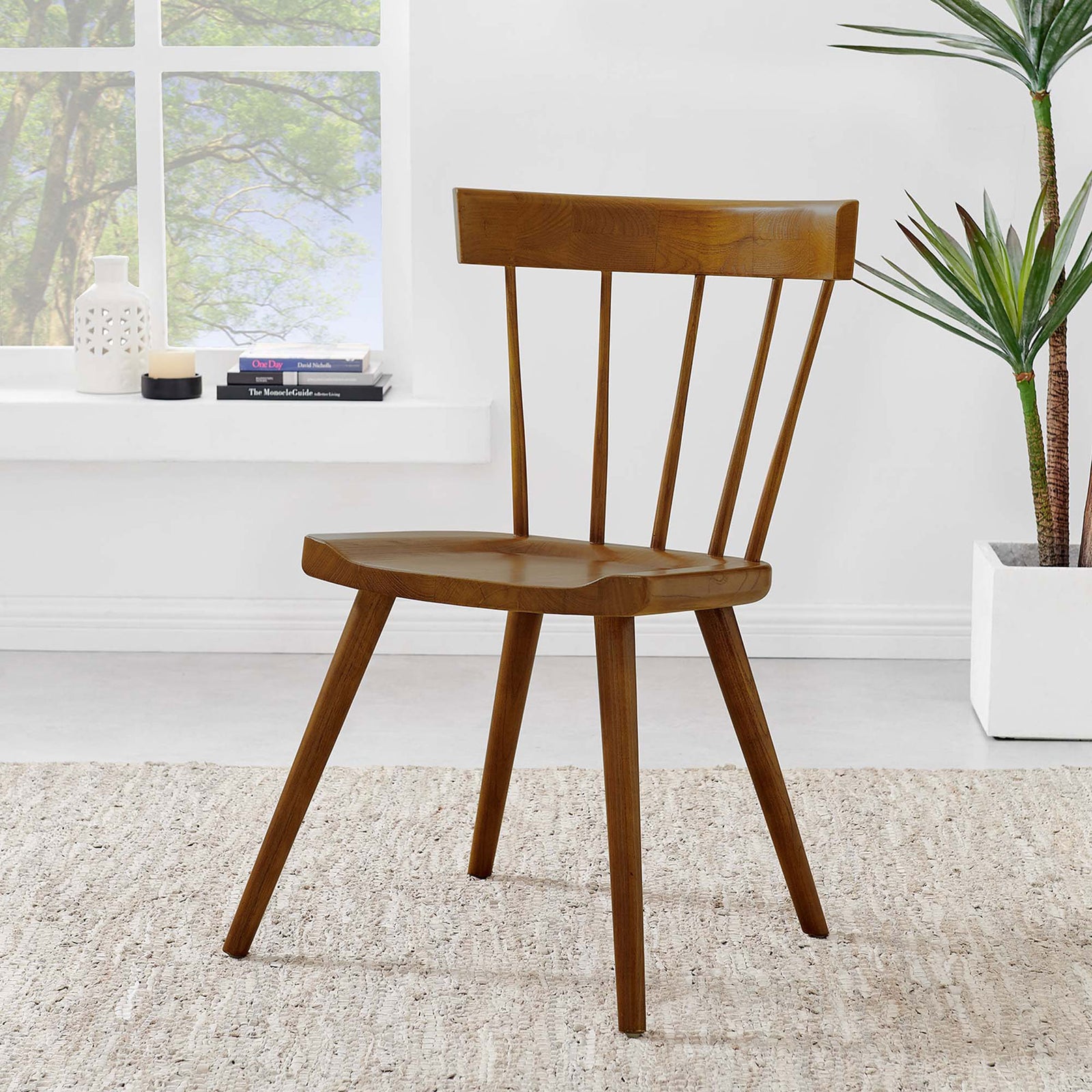 Walnut Sutter dining chair styled in a bright room with neutral rug and greenery for a warm welcome. || EEI-4650-WAL || front_angle_room