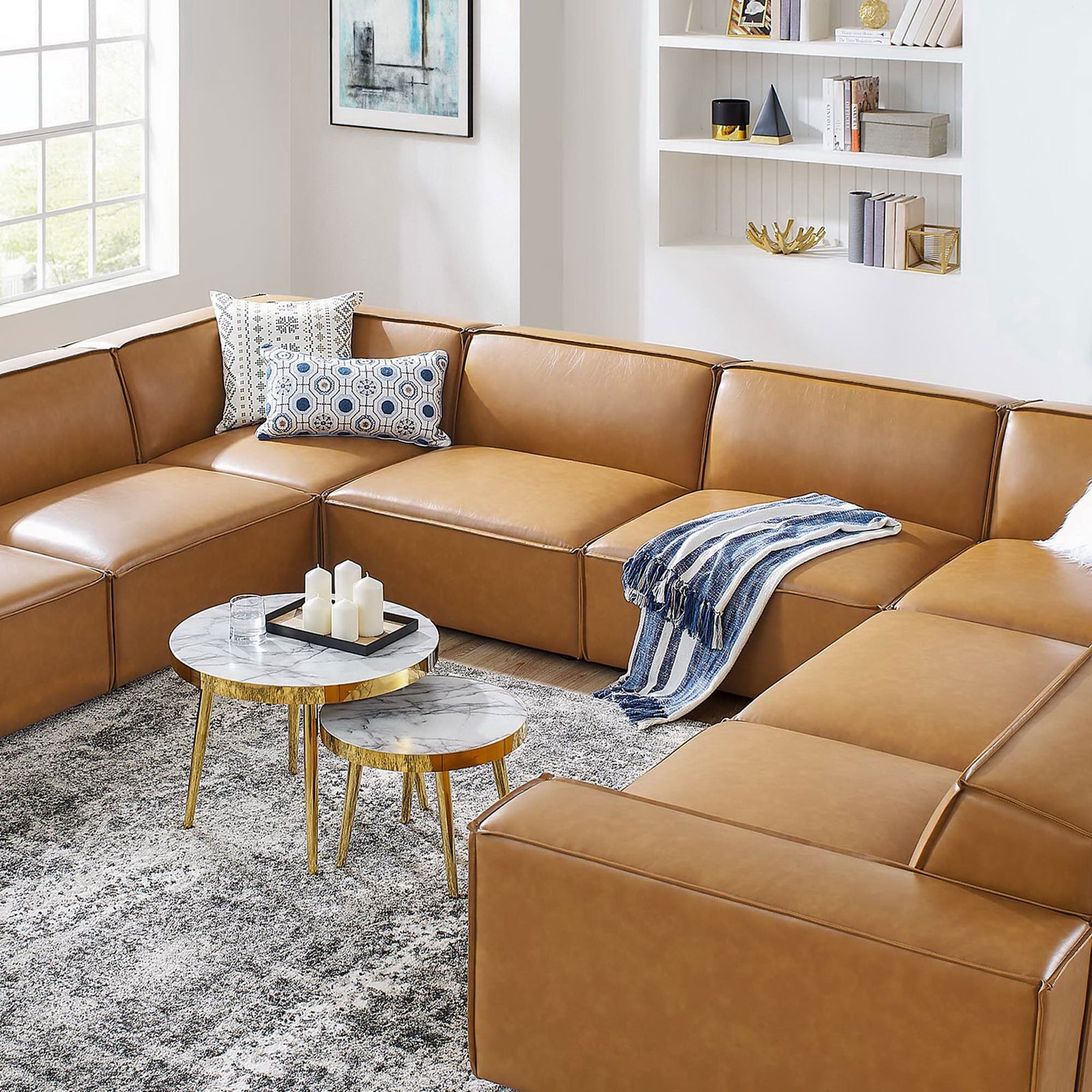 Cozy corner arrangement of the tan vegan leather sectional styled with pillows, throw blanket, and nesting tables || EEI-4717-TAN || front_angle_room