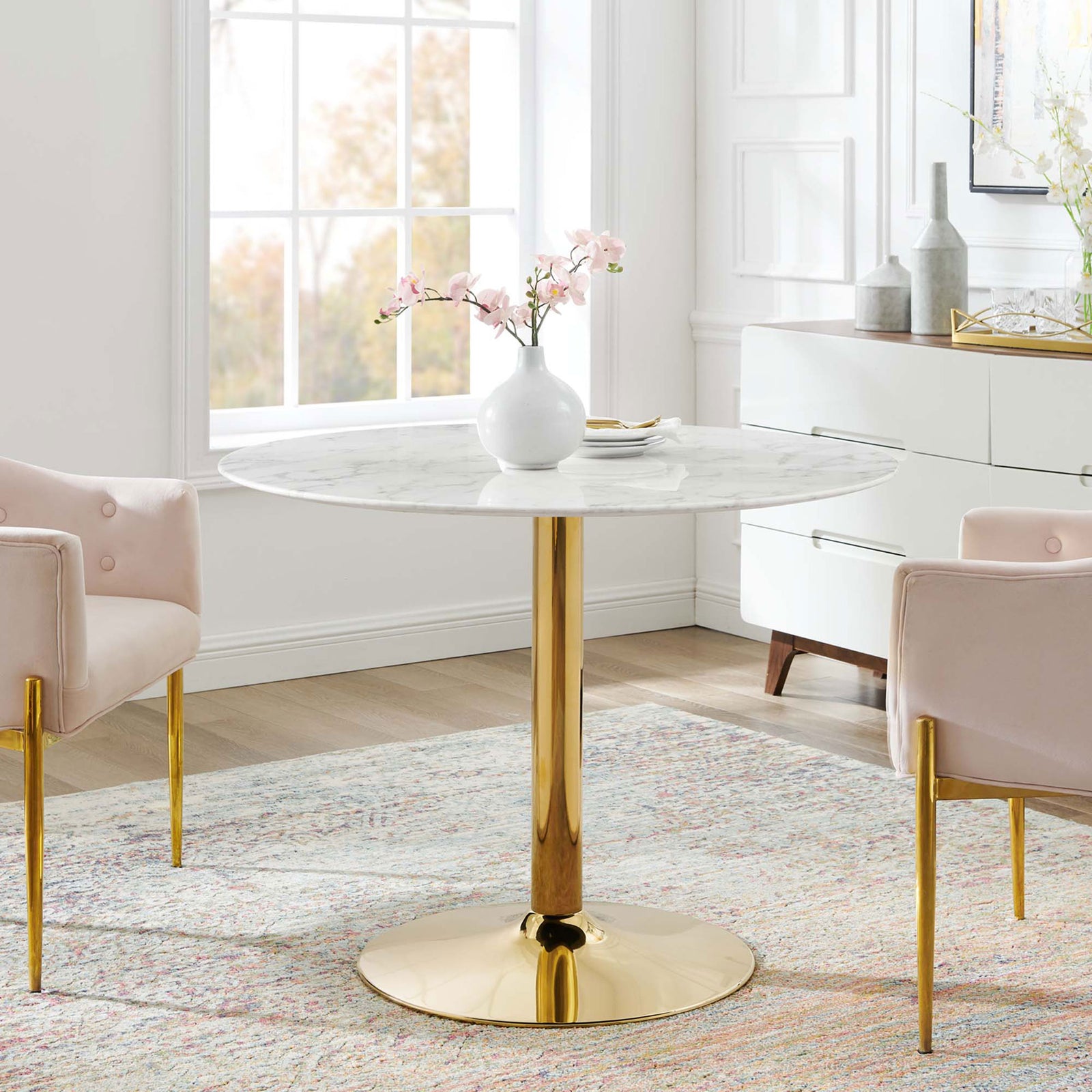 Larger round pedestal dining table anchoring a bright, modern living-dining area || EEI-4749-GLD-WHI || front_room