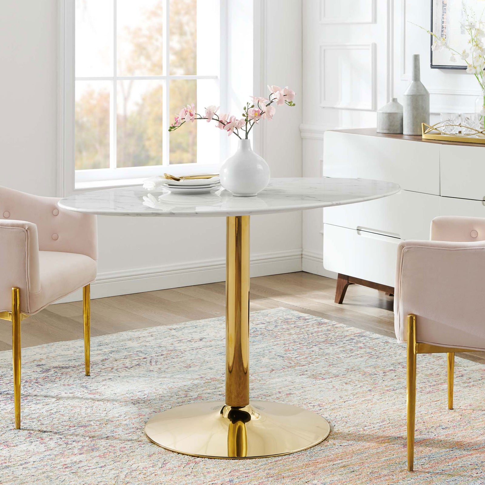 Oval pedestal dining table creating an elegant focal point in a sunlit dining room || EEI-4752-GLD-WHI || front_room