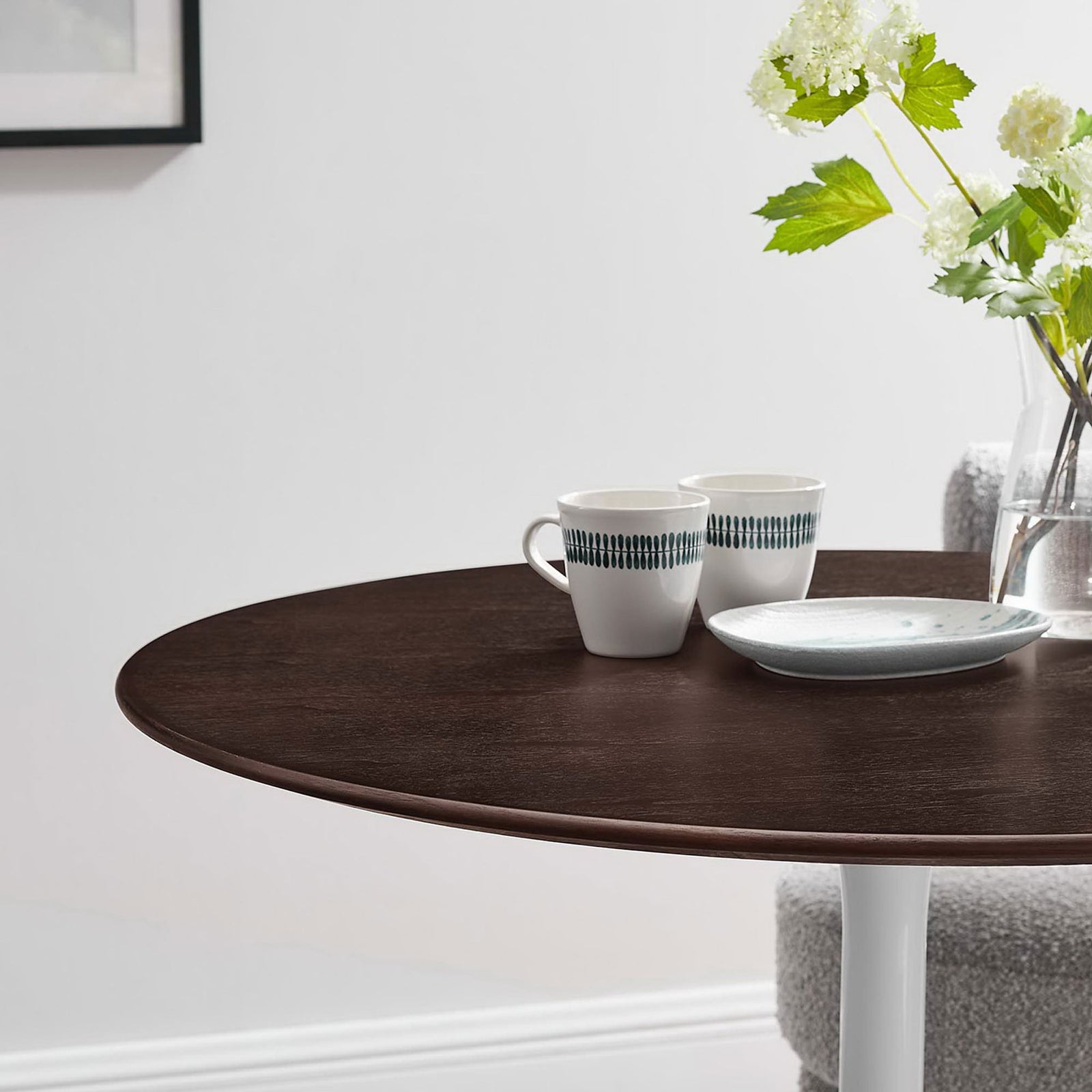 Cozy close up of round dining table styled with mugs, flowers, and minimalist decor || EEI-5157-WHI-CHE || detail_room