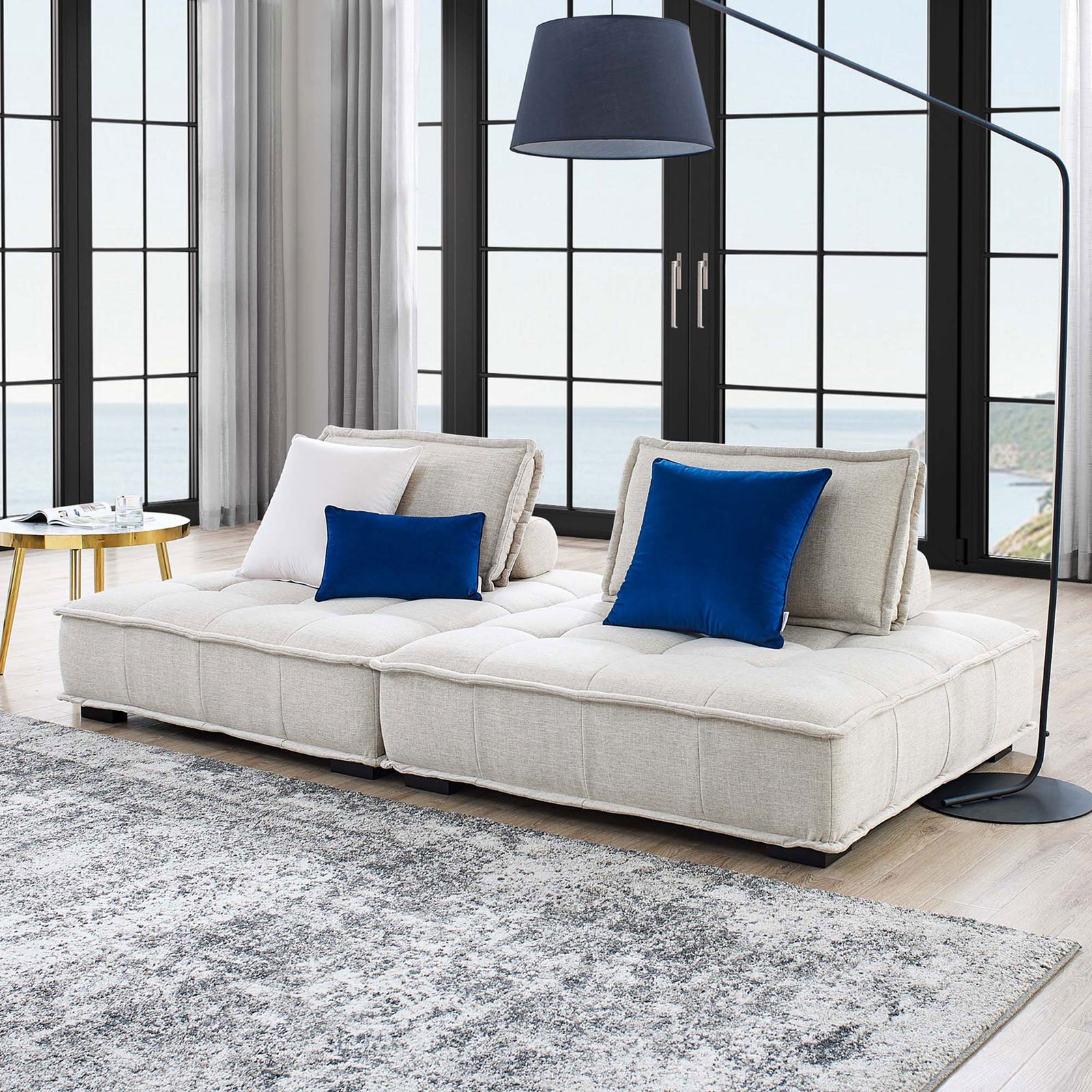Beige Saunter loveseat creates a cozy lounge centerpiece with tufted seat cushions and bolster pillows. || EEI-5204-BEI || front_angle_multi_room