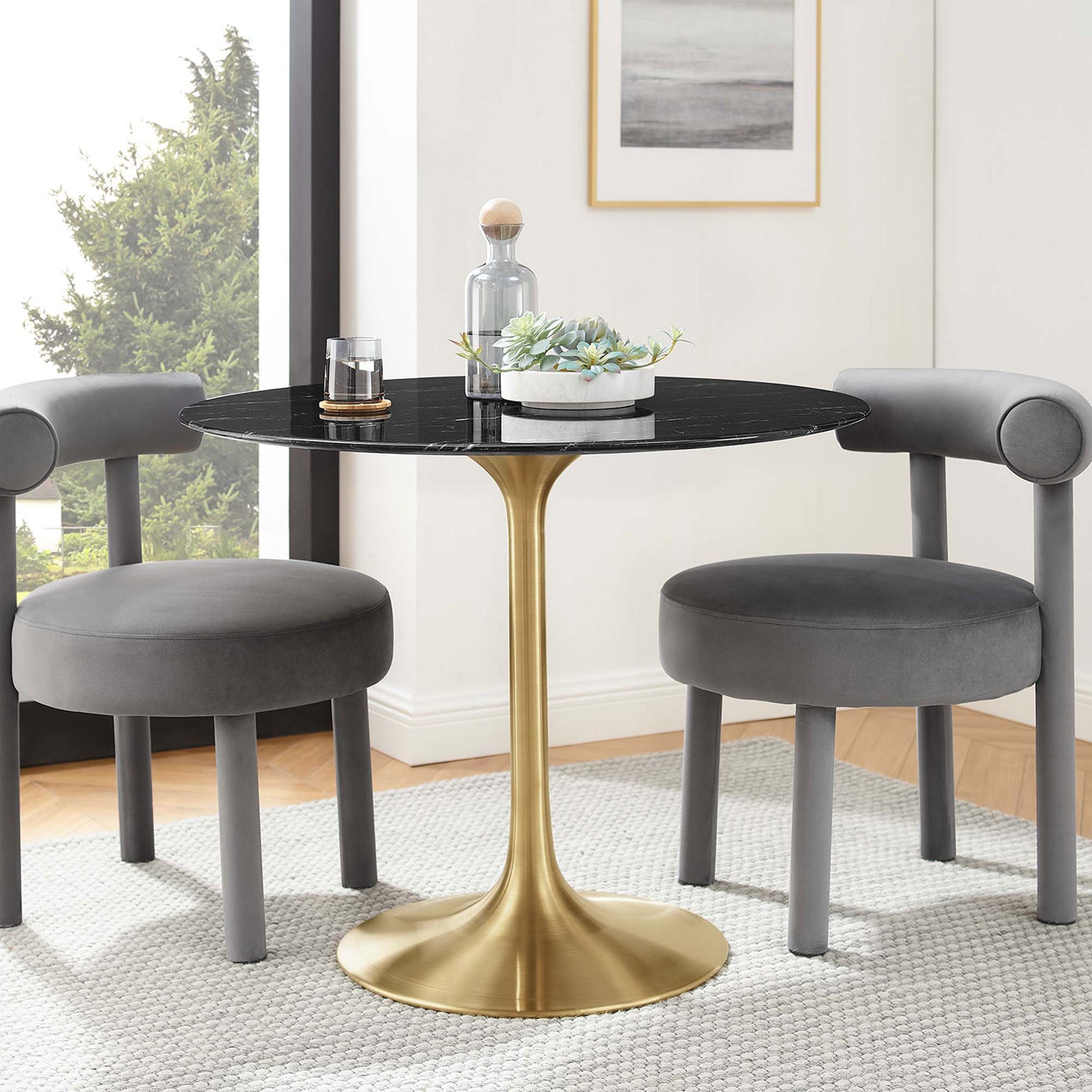36 inch black faux marble pedestal dining table styled with two gray chairs in a bright modern dining nook || EEI-5225-GLD-BLK || front_angle_room