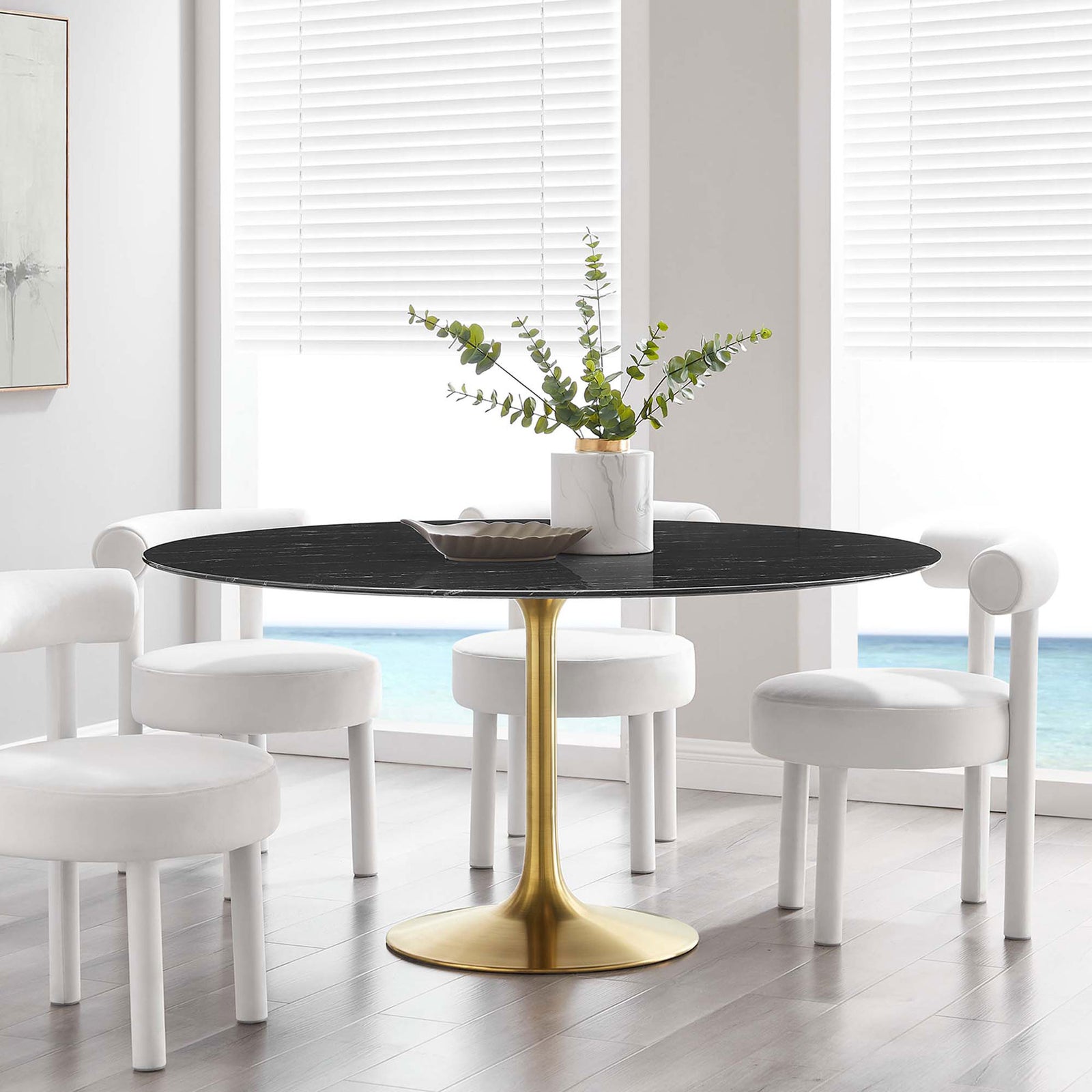60 inch black faux marble pedestal dining table surrounded by white chairs in an airy ocean view dining space || EEI-5241-GLD-BLK || front_angle_room
