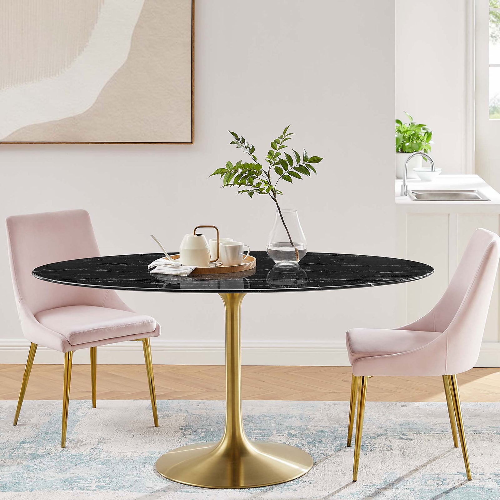Black oval pedestal dining table paired with blush upholstered chairs in a chic dining room. || EEI-5243-GLD-BLK || front_room