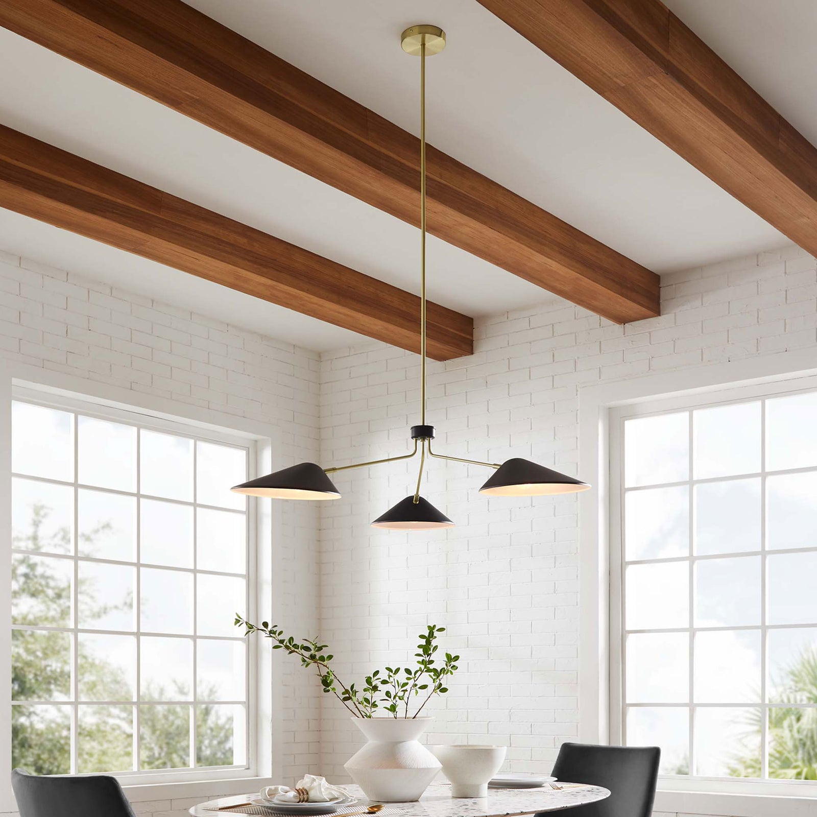 Adjustable three-light fixture enhances modern decor above the dining table with clean lines and bold contrast || EEI-5297-BLK || front_angle_on_room