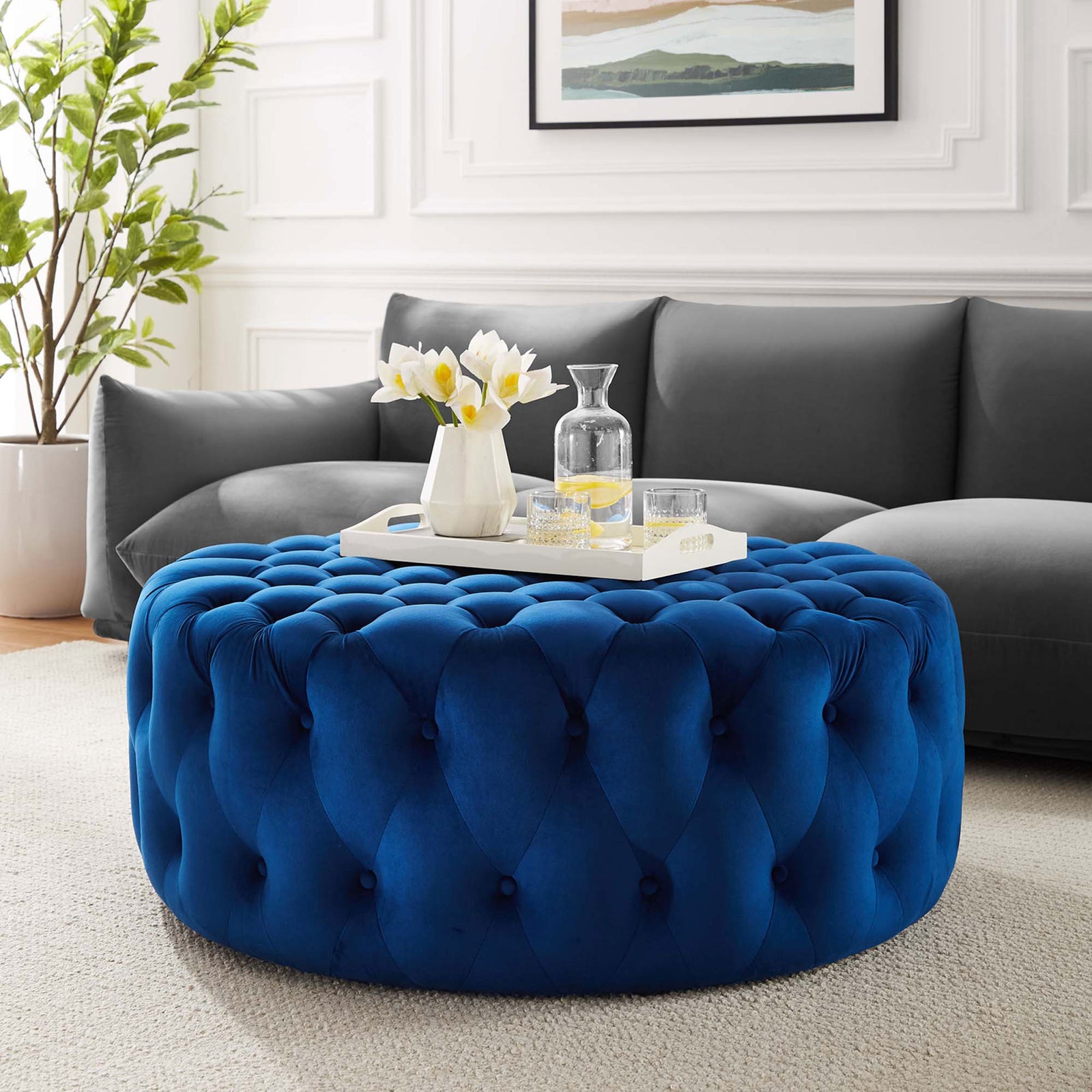Navy round velvet ottoman anchors a contemporary living room with plush extra seating and a bold pop of color || EEI-5469-NAV || front_room