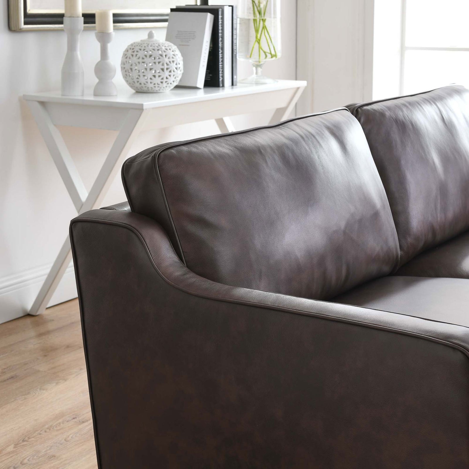 Impart brown leather sofa styled with accent pillows, highlighting smooth back cushions in a bright living room || EEI-5553-BRN || detail_room
