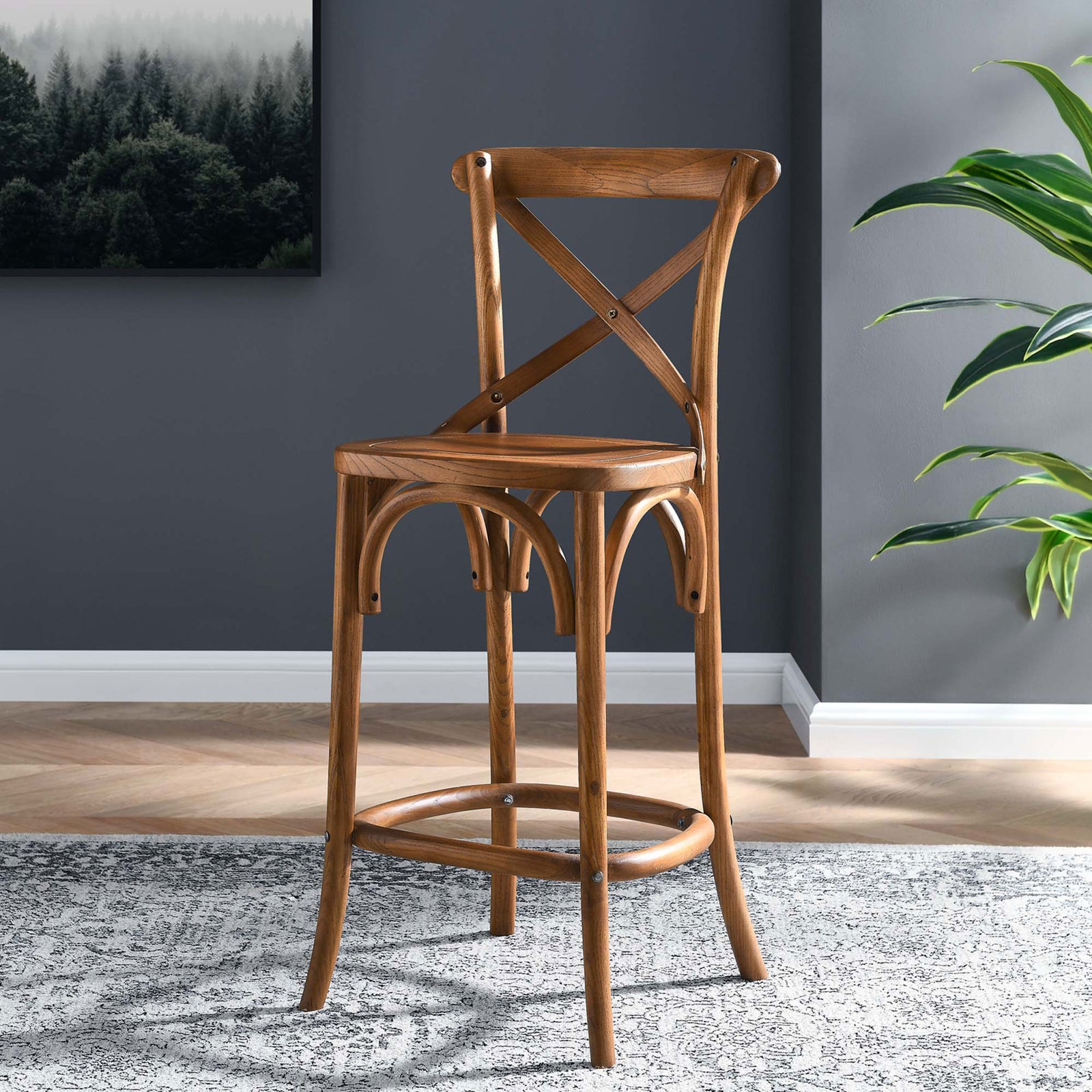 Warm walnut counter stool adds inviting farmhouse character to the kitchen with its X-back and arched base || EEI-5562-WAL || front_angle_room