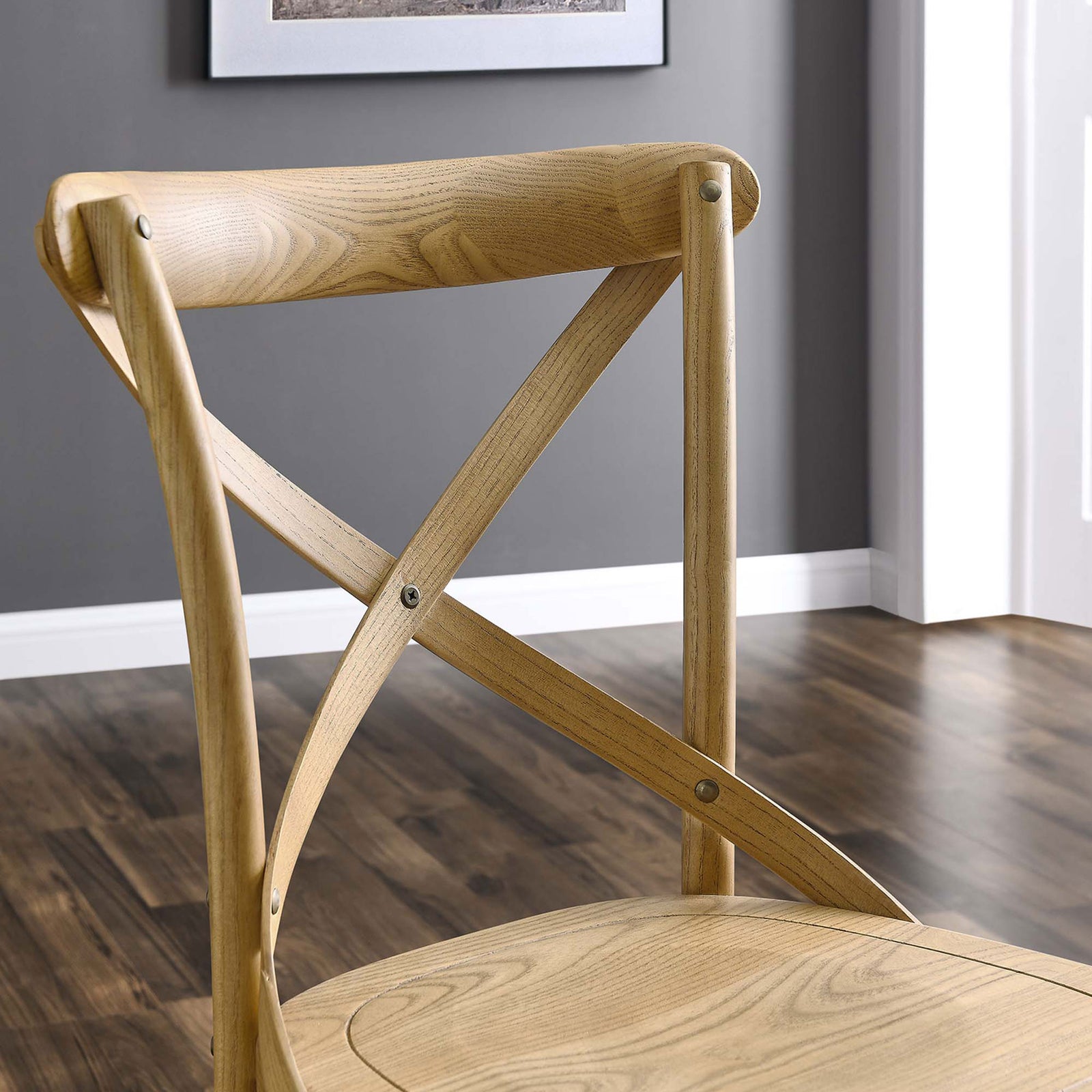 Close-up of natural wood cross-back chair against warm wood flooring in a modern room || EEI-5564-NAT || detail_room