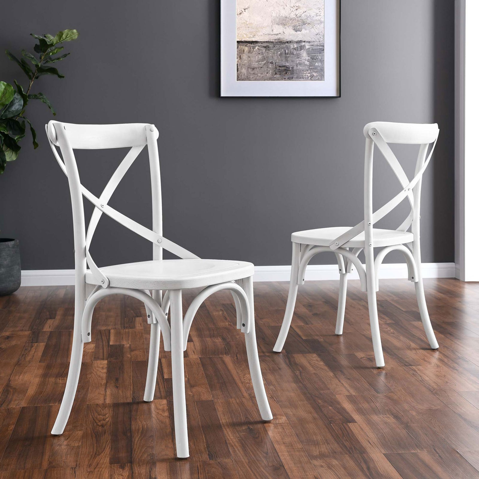 Two white cross-back dining chairs arranged in a cozy modern dining space || EEI-5564-WHI || front_angle_room