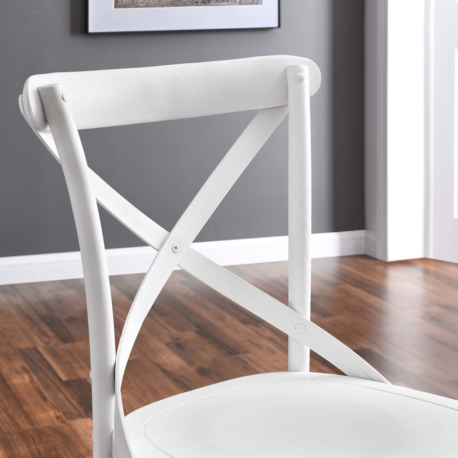 Close-up of white dining chair backrest against warm wood flooring and gray wall || EEI-5564-WHI || detail_room