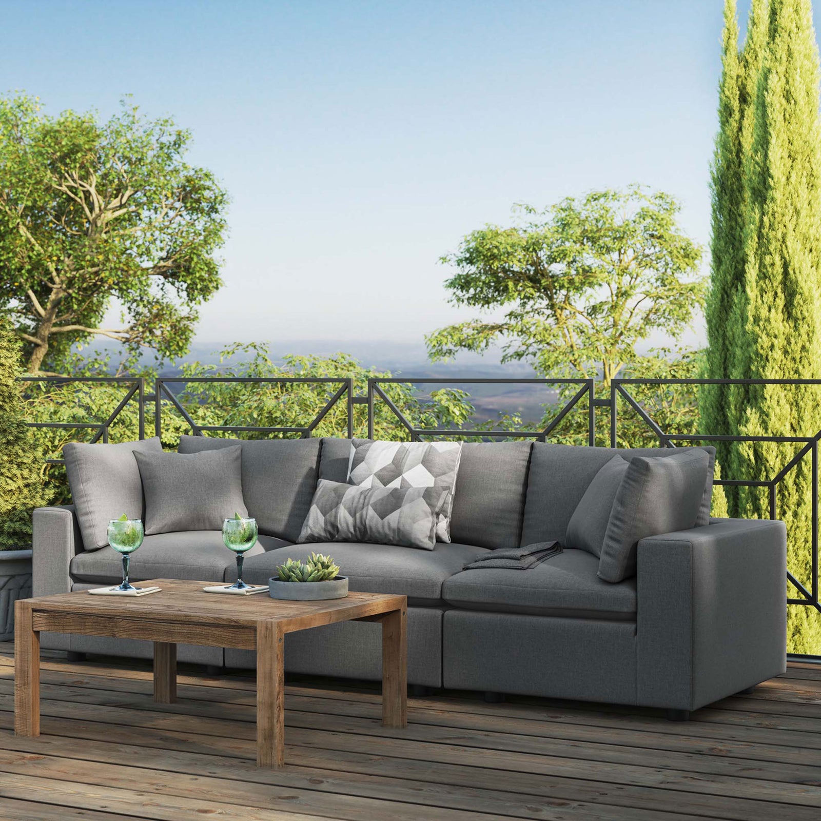 Charcoal three-seat outdoor sofa on a scenic rooftop deck arranged with a rustic wood coffee table || EEI-5578-CHA || front_angle_room