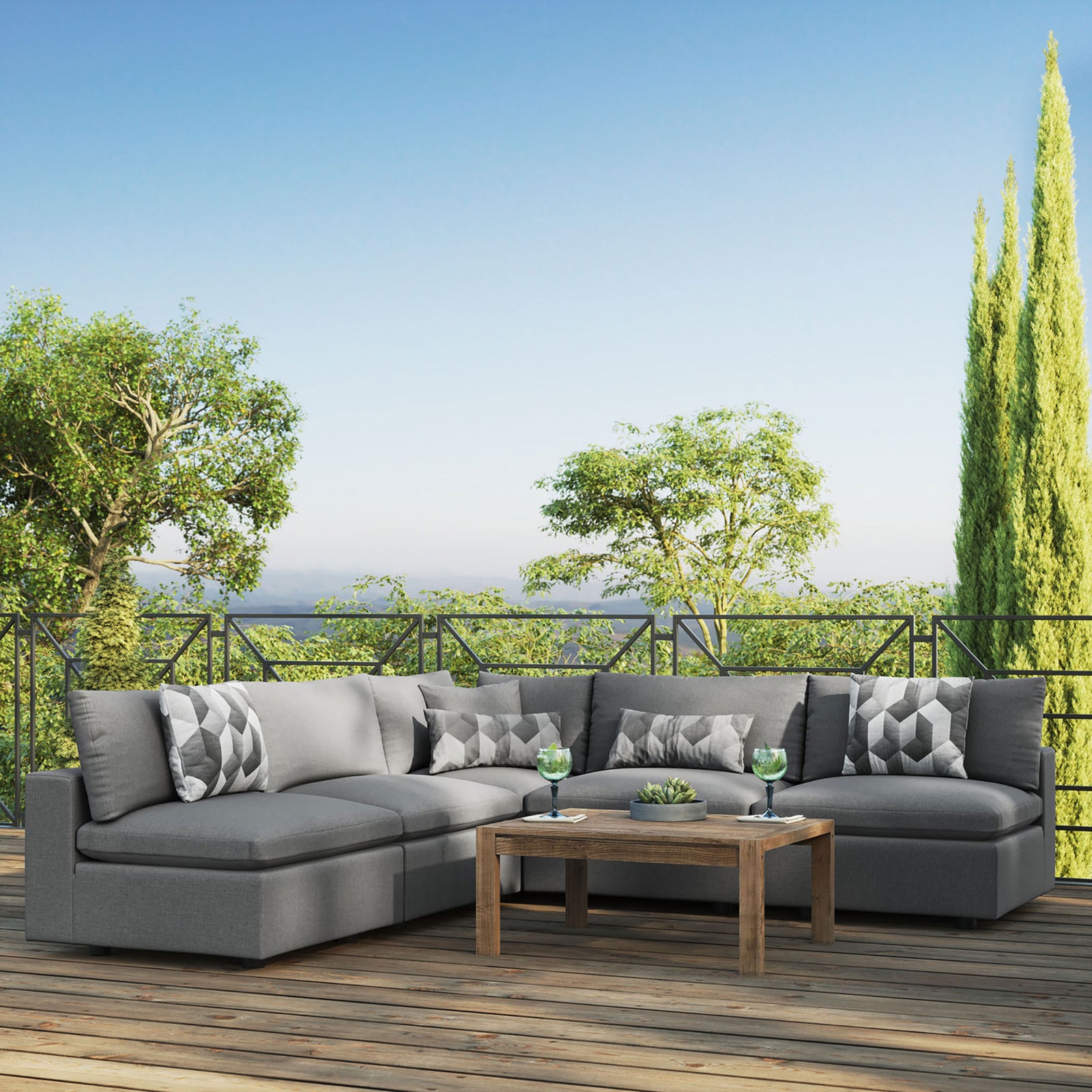 Charcoal Commix outdoor sectional creating a spacious lounge on a sunny balcony with greenery. || EEI-5587-CHA || front_angle_room