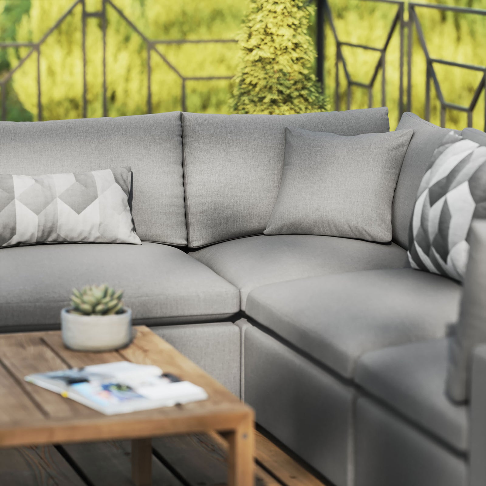 Charcoal Commix sectional styled on a patio with accent pillows and a wood coffee table for casual outdoor gatherings. || EEI-5589-CHA || detail_room