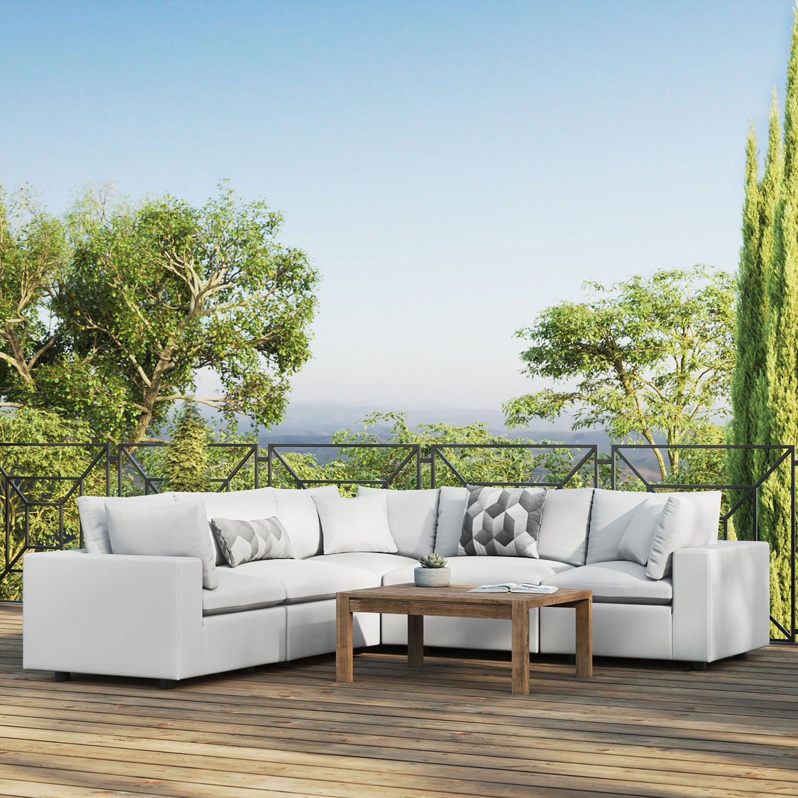 White Commix outdoor sectional defining a bright deck seating area with a wood table and lush garden views. || EEI-5589-WHI || front_angle_room