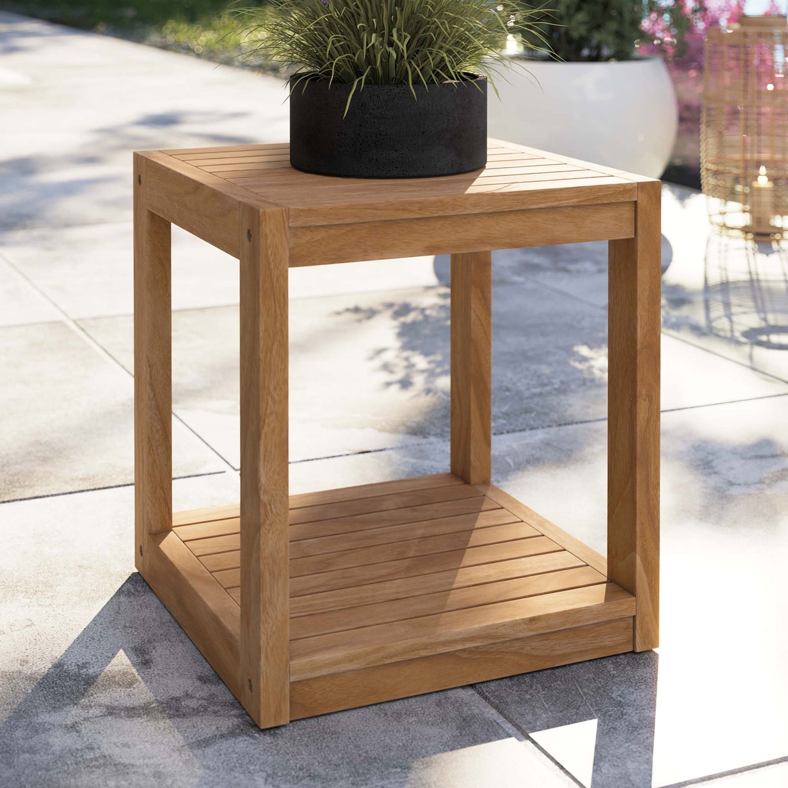 Teak cube side table on a modern patio, styled with a planter on the slatted tabletop || EEI-5607-NAT || front_angle_room