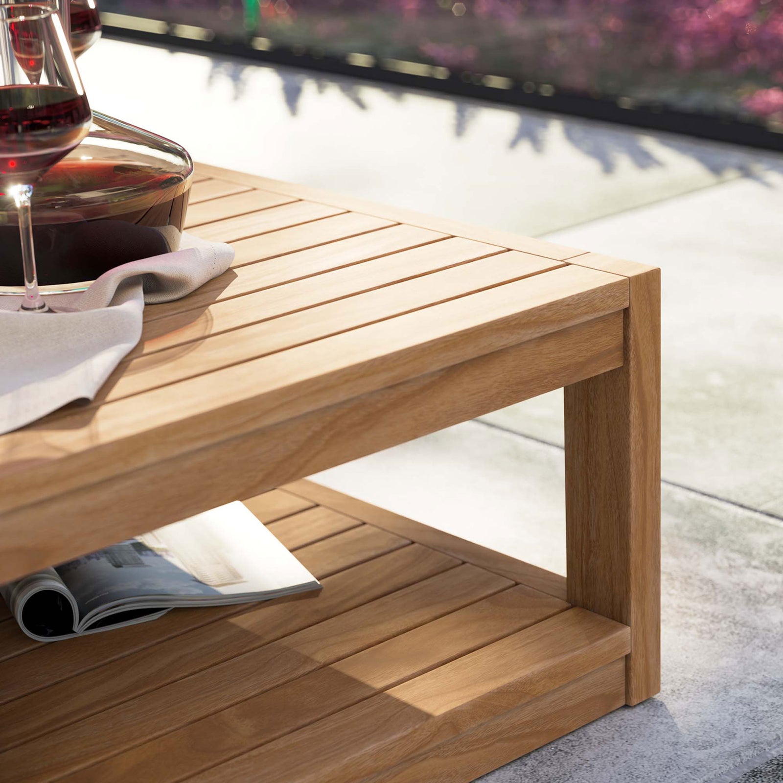 Teak patio coffee table styled with wine glasses and magazine on modern outdoor terrace || EEI-5608-NAT || detail_room