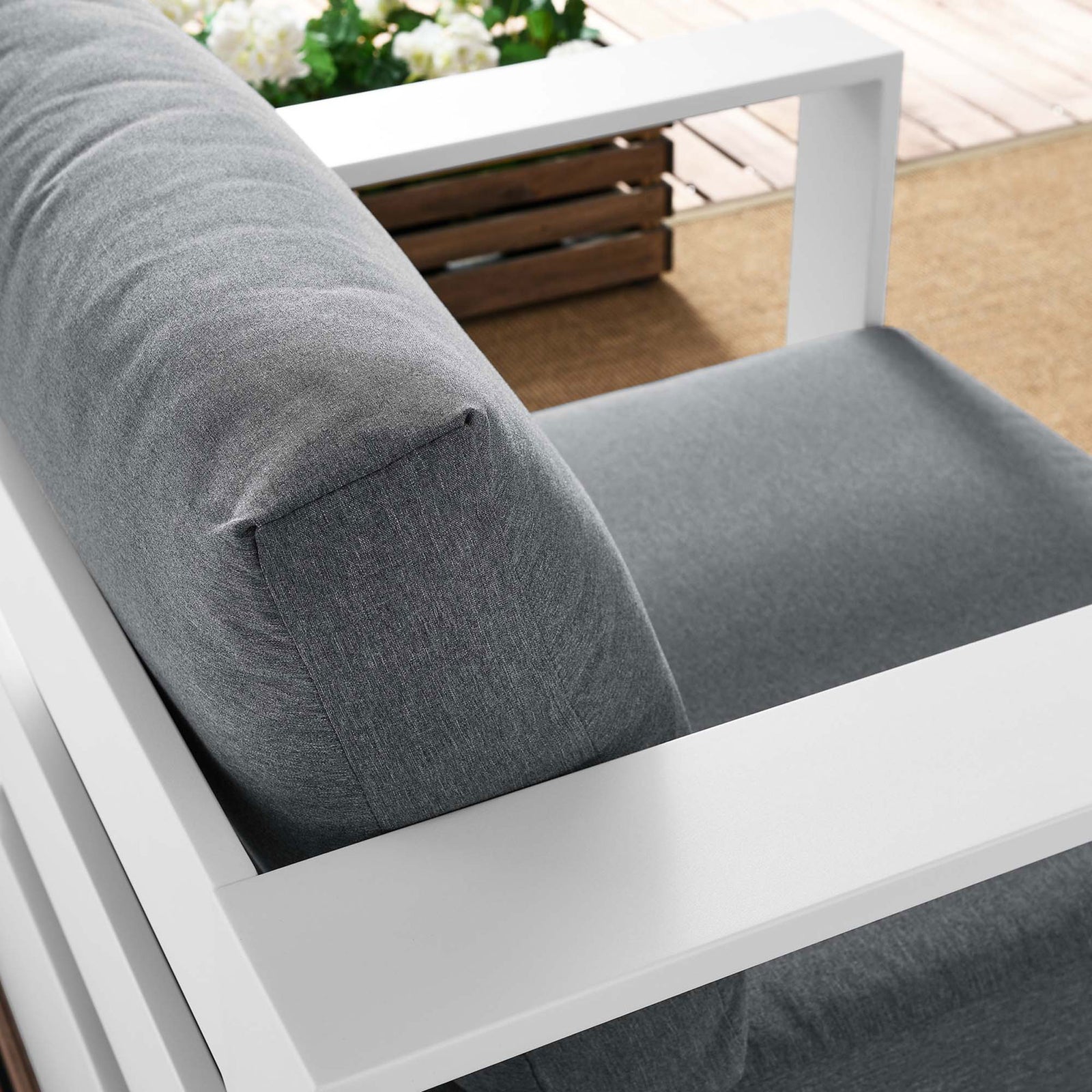 Tahoe armchair back cushion and white armrest arranged outdoors with textured charcoal upholstery || EEI-5675-WHI-CHA || detail_room