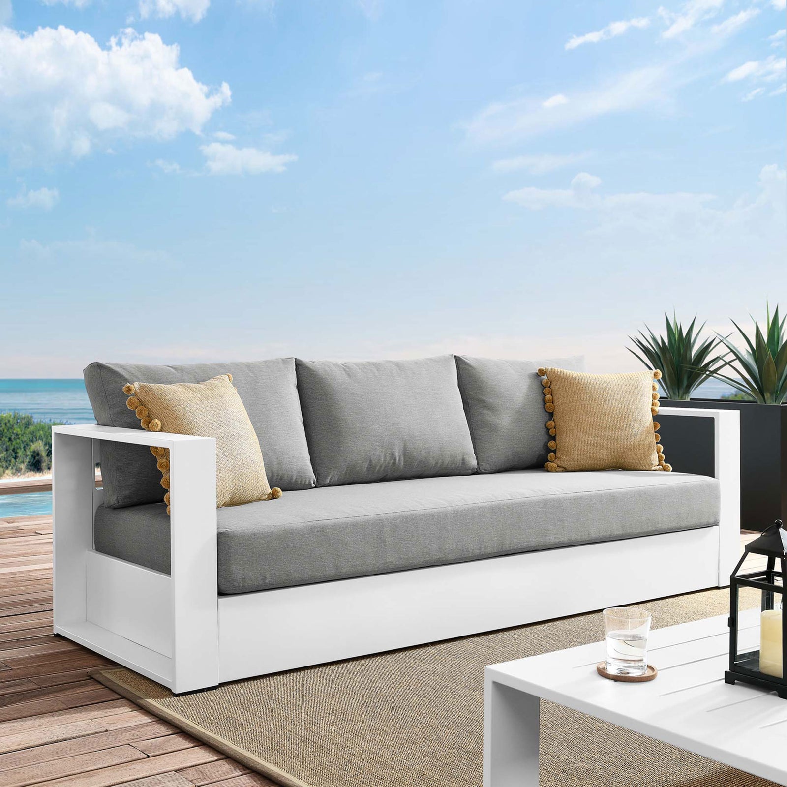 Tahoe outdoor sofa with white frame and gray cushions styled on a sunny deck with pillows. || EEI-5676-WHI-GRY || front_angle_room