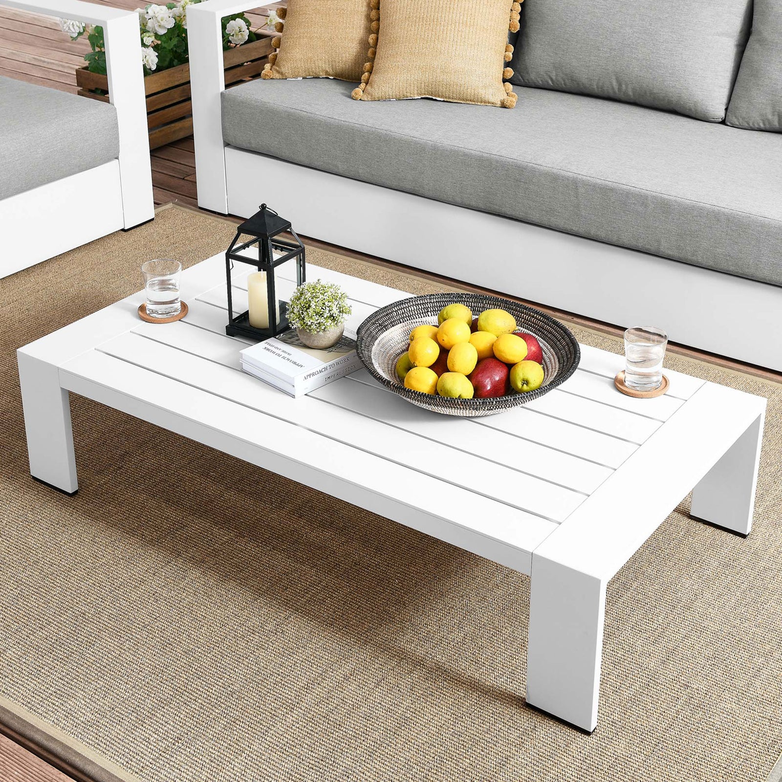 White aluminum coffee table anchoring a contemporary patio lounge with sofas and accents || EEI-5677-WHI || front_angle_room