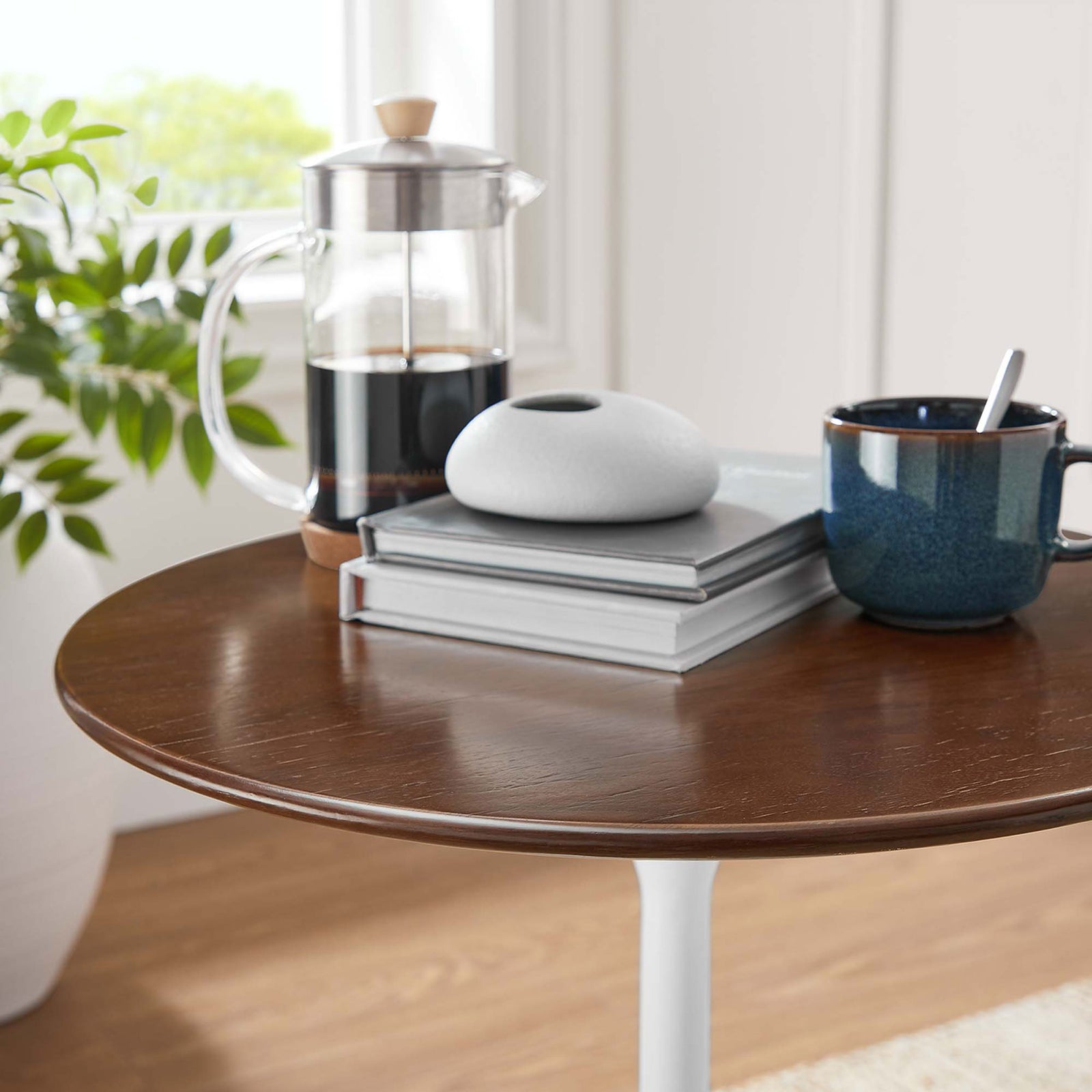 Warm walnut tabletop styled with coffee press, books, and decor in a bright living room || EEI-5679-WHI-WAL || detail_room