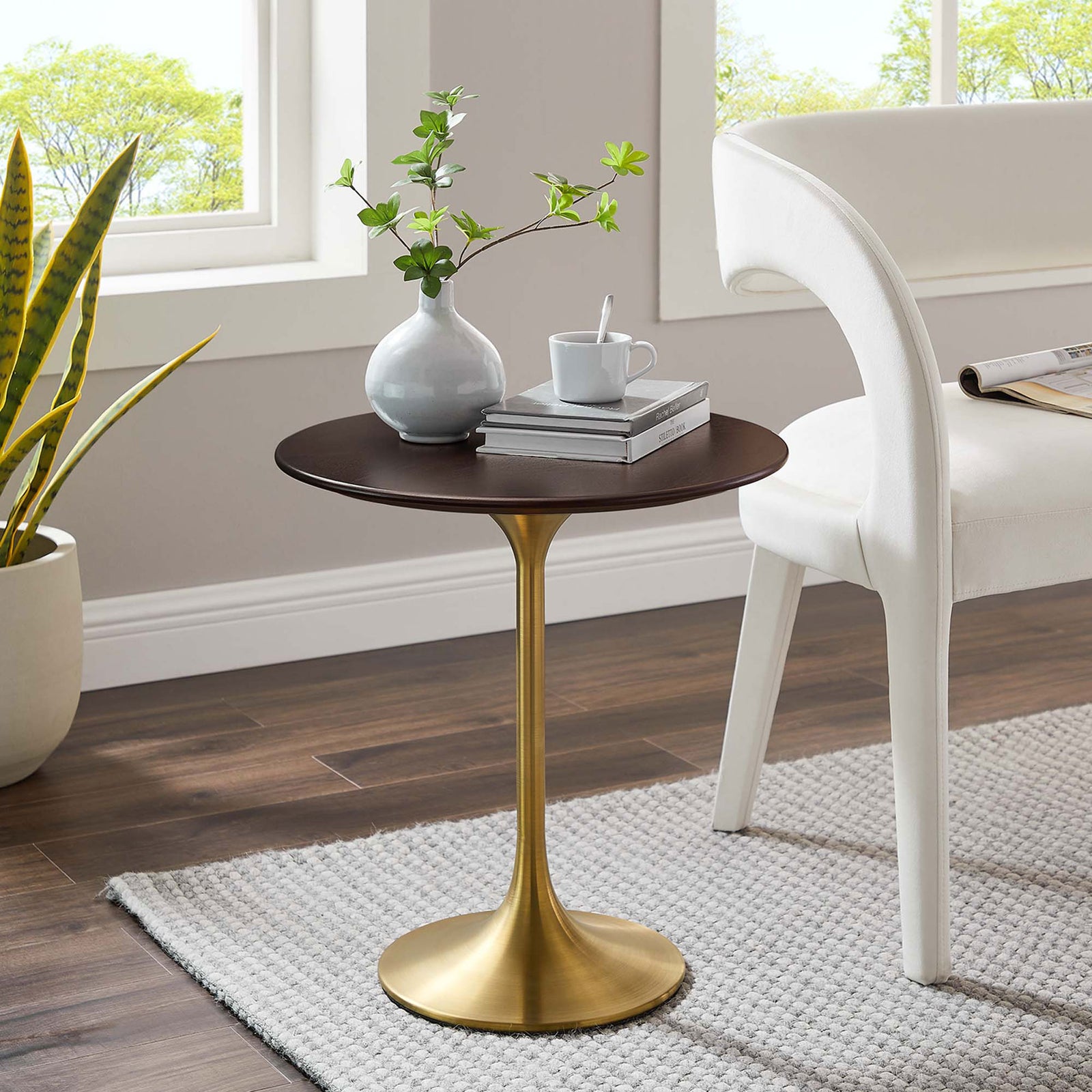 Round side table with walnut grain top and gold pedestal base styled beside a modern accent chair || EEI-5684-GLD-CHE || front_angle_room