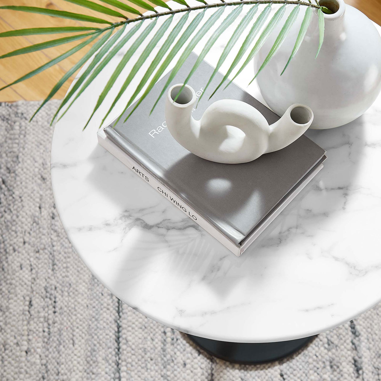 Faux marble side table styled with books and modern decor on a textured rug || EEI-5690-BLK-WHI || detail_room