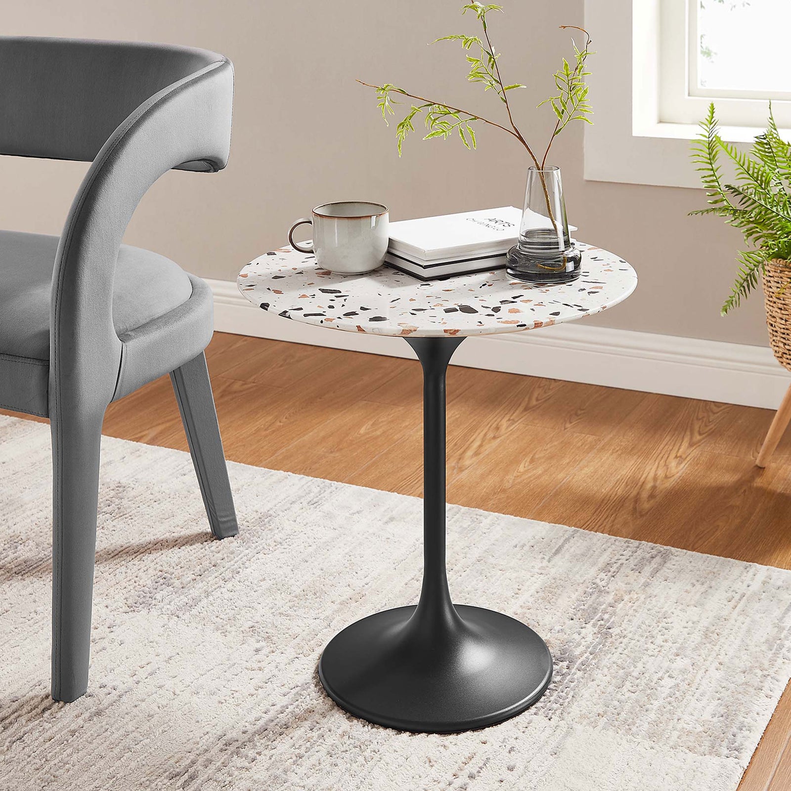 Modern terrazzo side table beside a gray chair on a neutral rug in a bright living room || EEI-5692-BLK-TER || front_angle_room