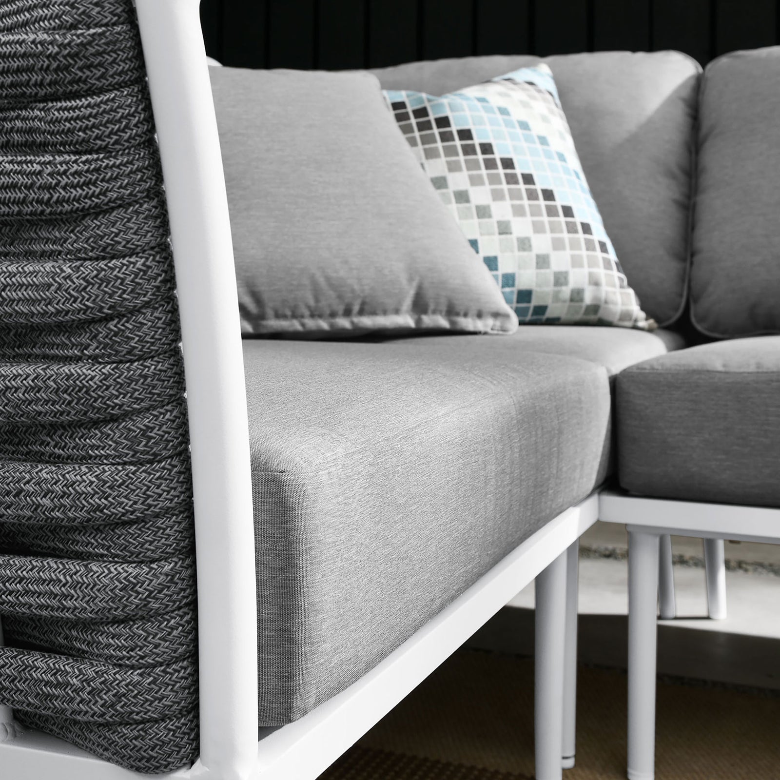 Outdoor sectional styling pairs soft gray cushions with rope accents, patterned pillows, and a neutral patio setting. || EEI-5753-WHI-GRY || detail_room