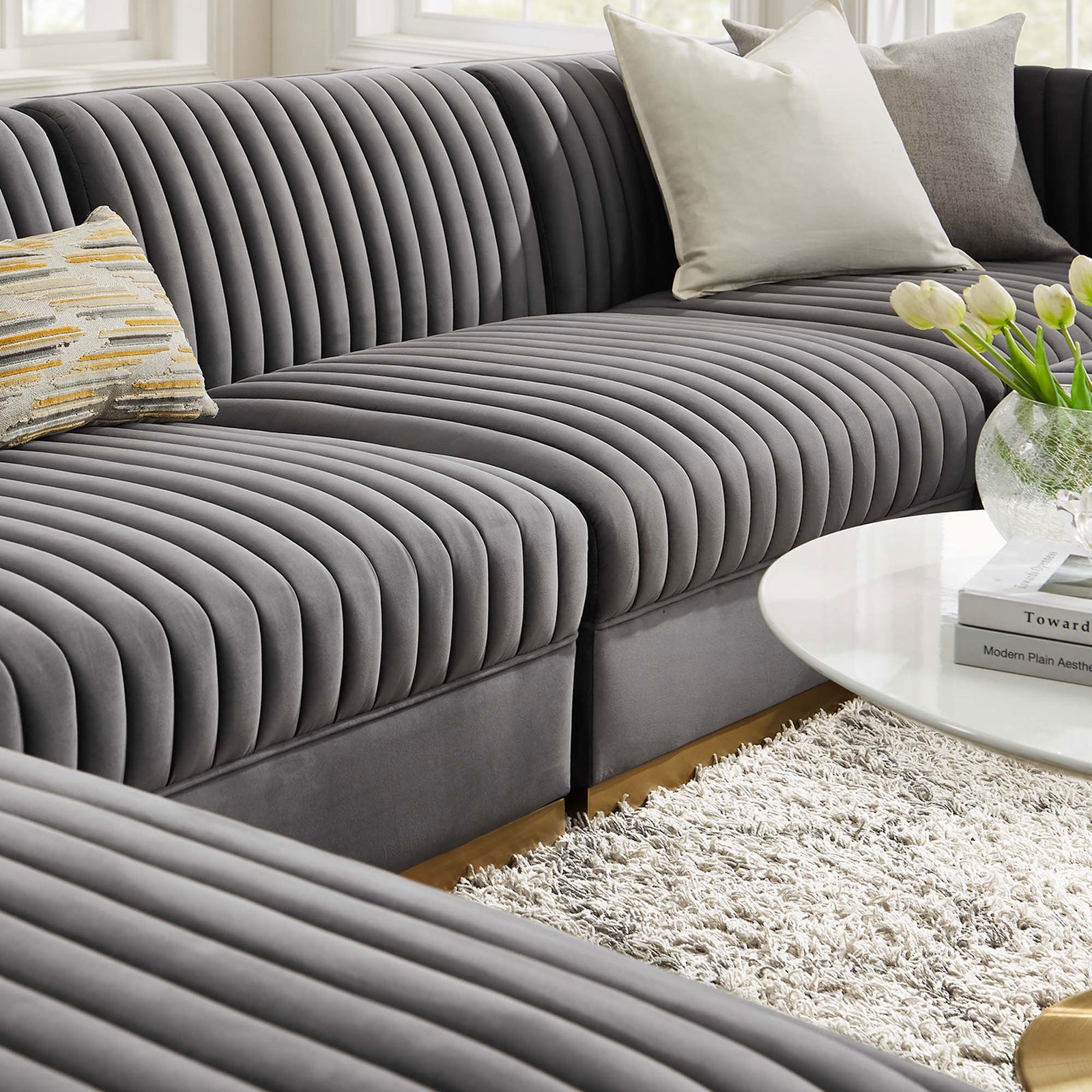 Inviting gray velvet sectional with plush channel tufting, layered pillows, and cozy living room decor. || EEI-5841-GRY || detail_room