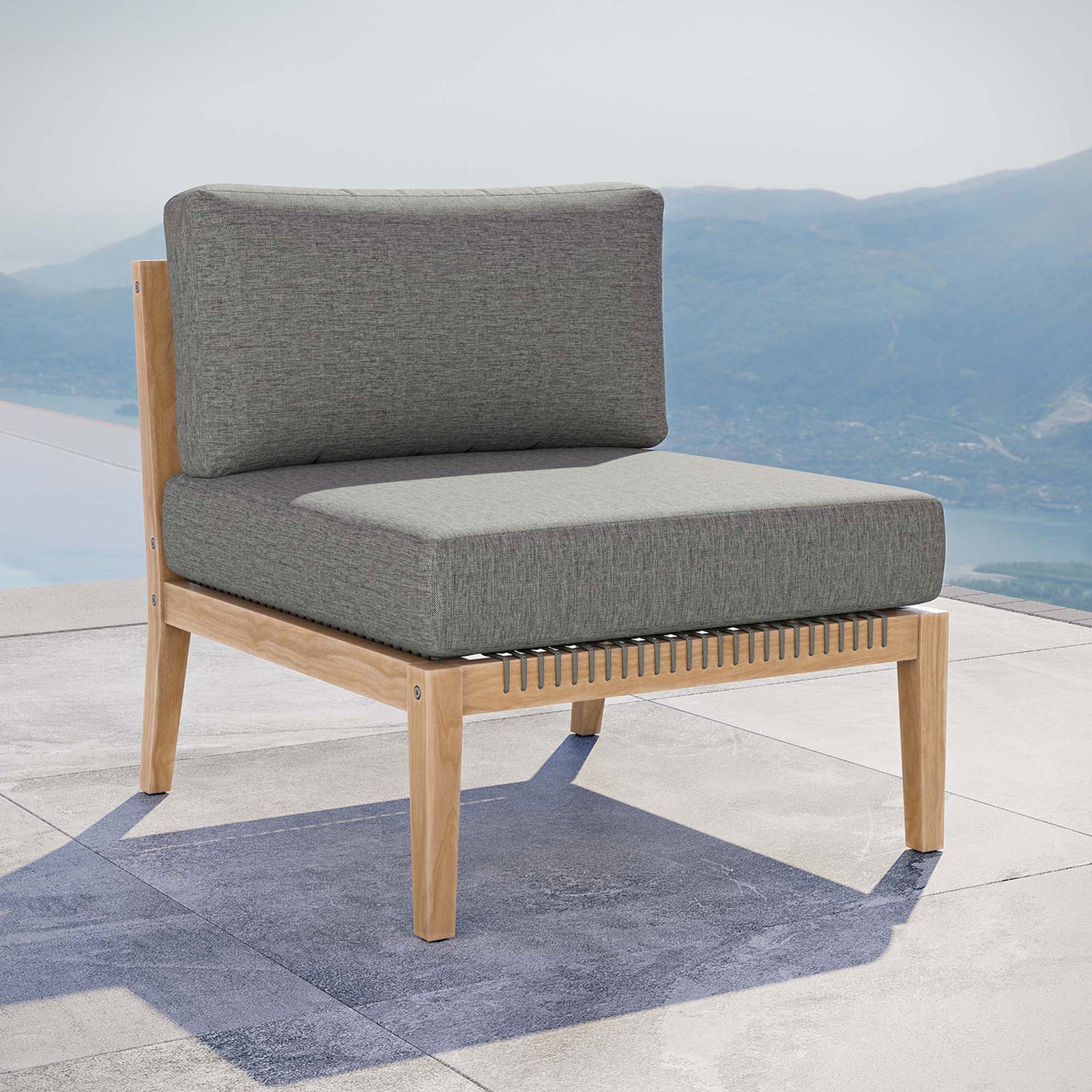 Gray graphite teak armless chair styled on a terrace, ready to anchor a chic outdoor lounge area || EEI-5856-GRY-GPH || front_angle_room