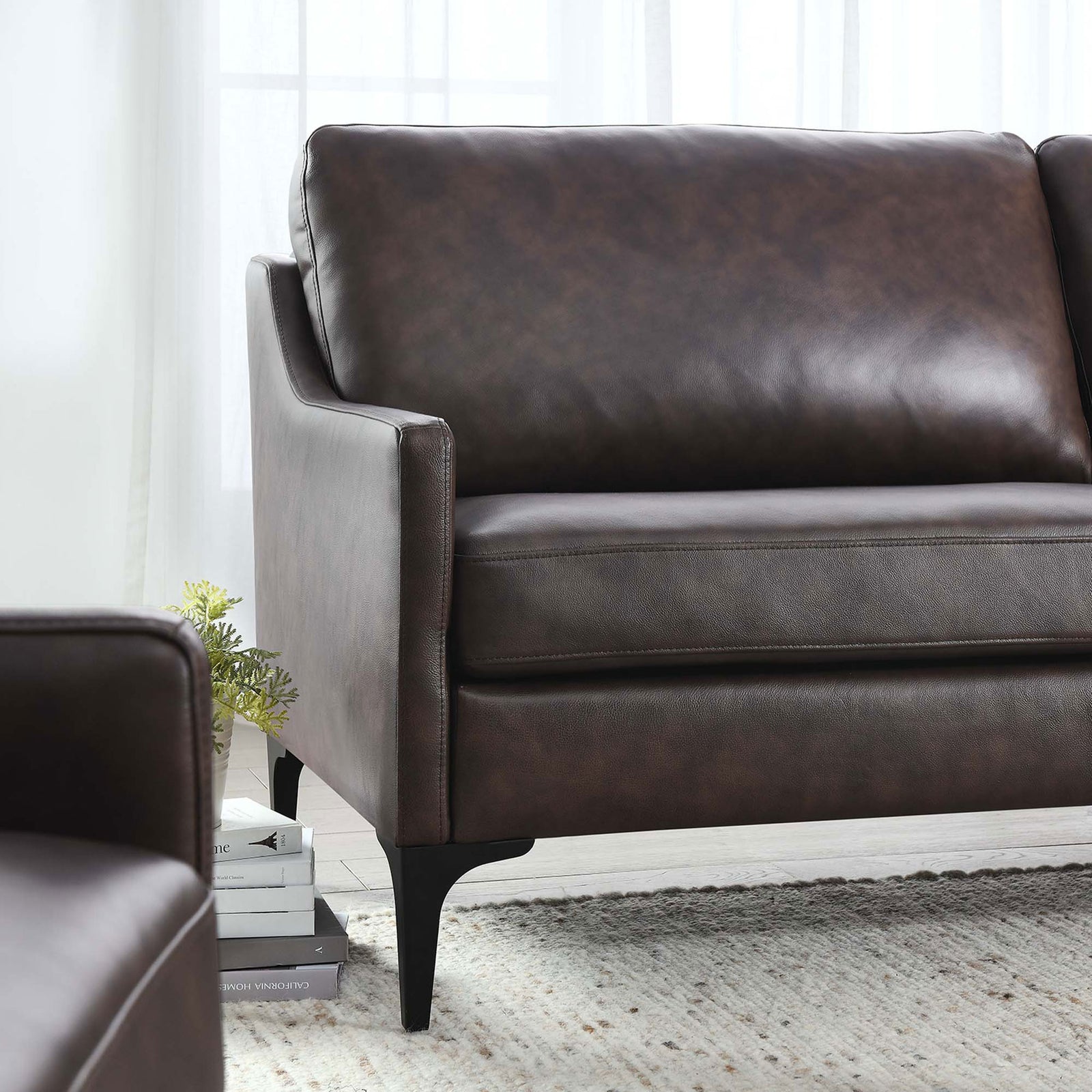 Brown leather sofa arm and cushions styled in a bright living room, pairing modern comfort with casual warmth || EEI-6018-BRN || detail_room