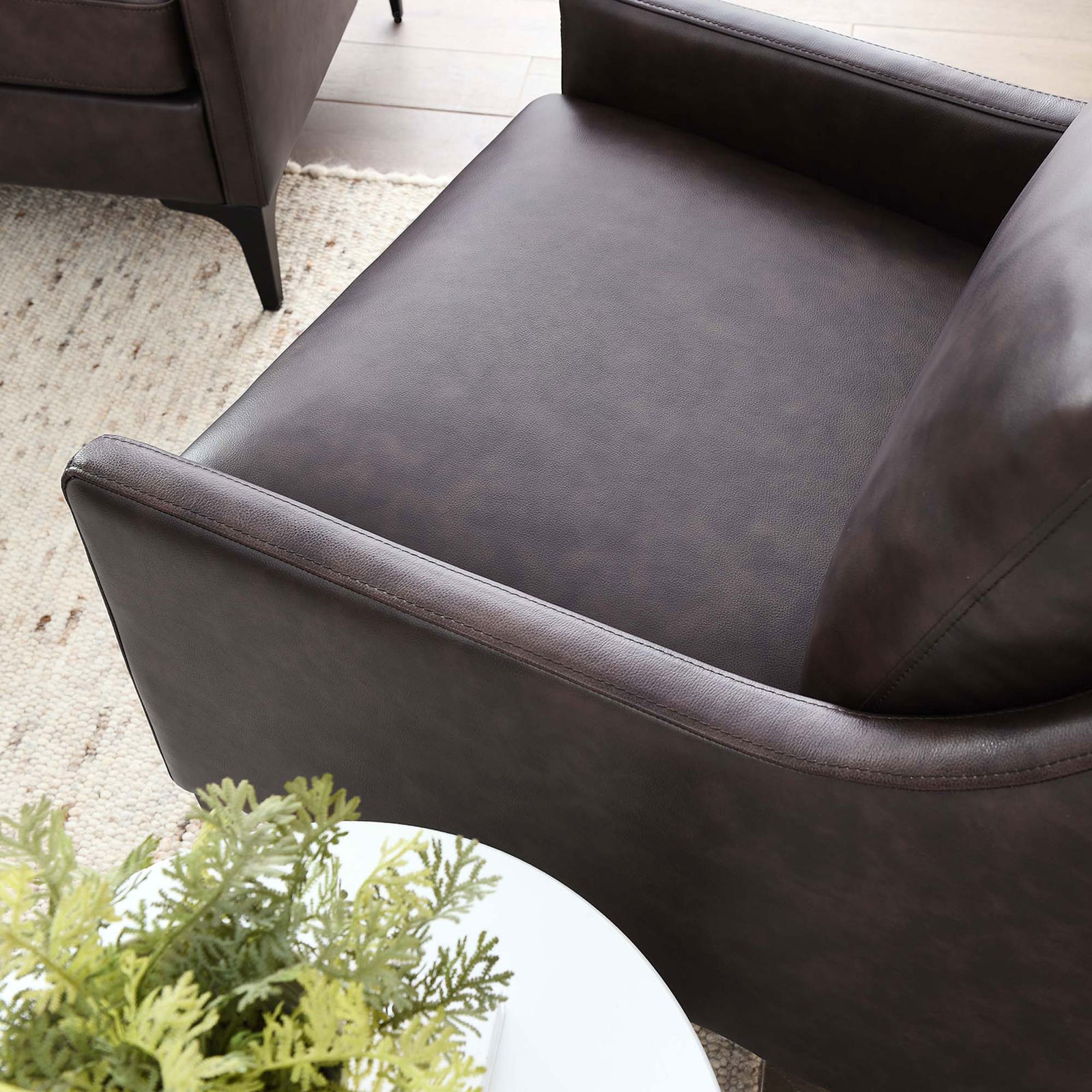 Smooth leather seat and gently curved armrest bring elevated comfort to modern living spaces || EEI-6022-BRN || detail_room