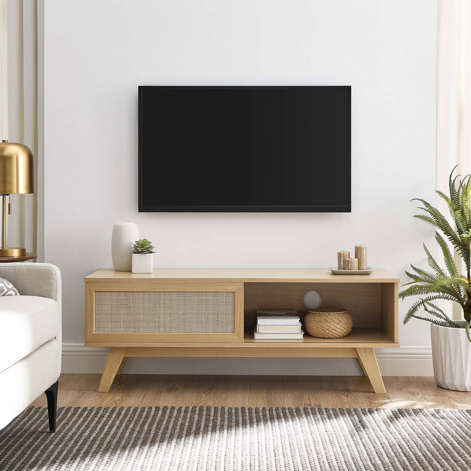 Oak tv stand with rattan sliding door and open shelf styled in a bright living room || EEI-6039-OAK || front_angle_room