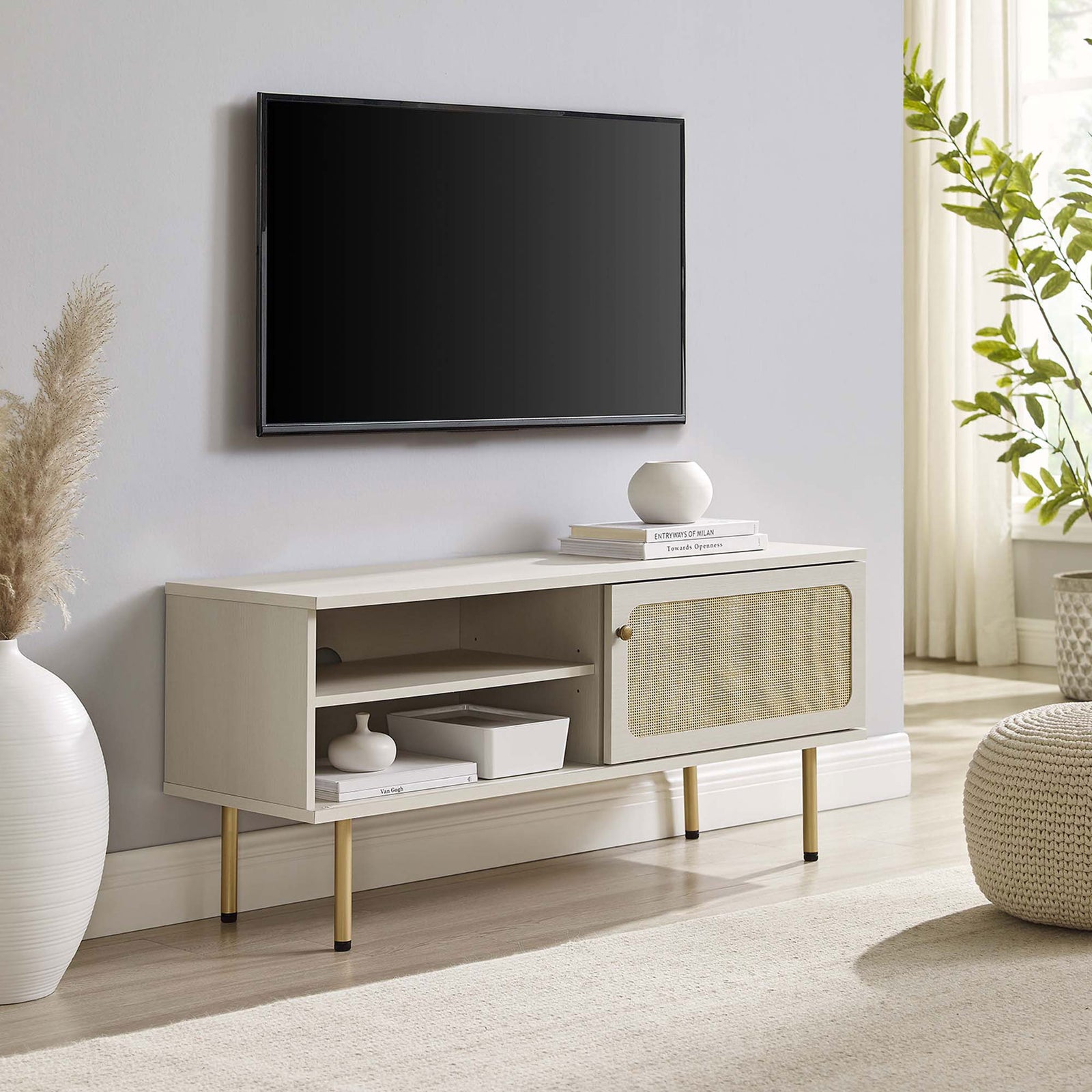 White TV console with rattan sliding door and gold legs complementing a calm, neutral living space. || EEI-6044-WHI || front_angle_room