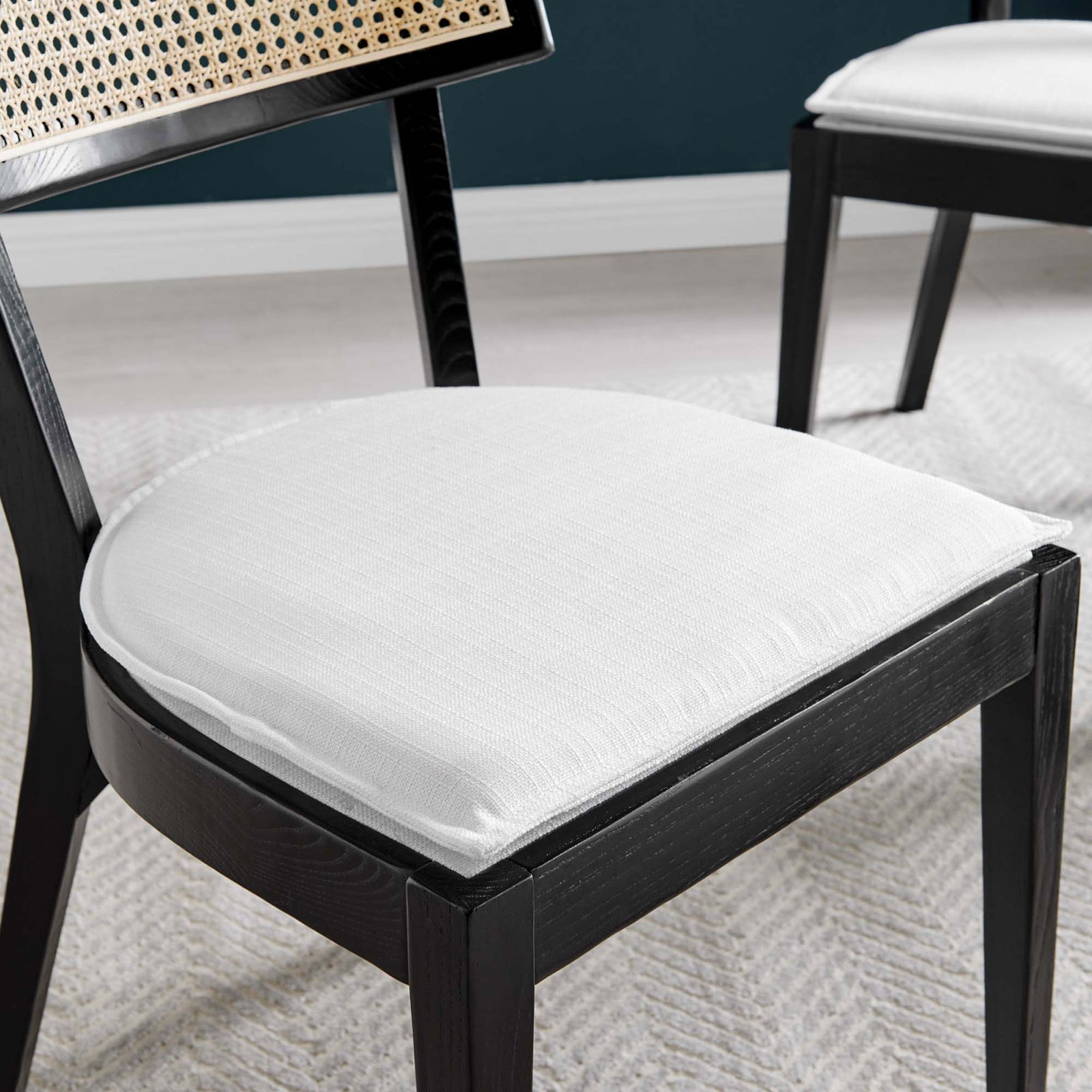 White upholstered seat cushion on black wood dining chair styled over a neutral woven rug || EEI-6080-BLK-WHI || detail_room