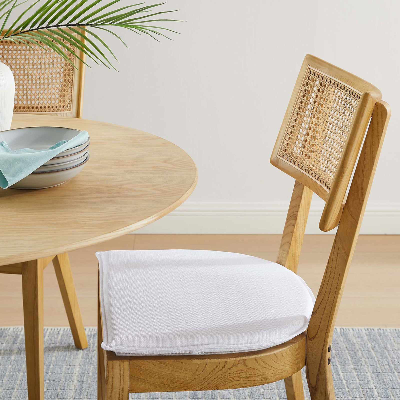 White seat cushion and woven rattan back bring soft contrast to the natural wood dining table || EEI-6080-NAT-WHI || detail_room