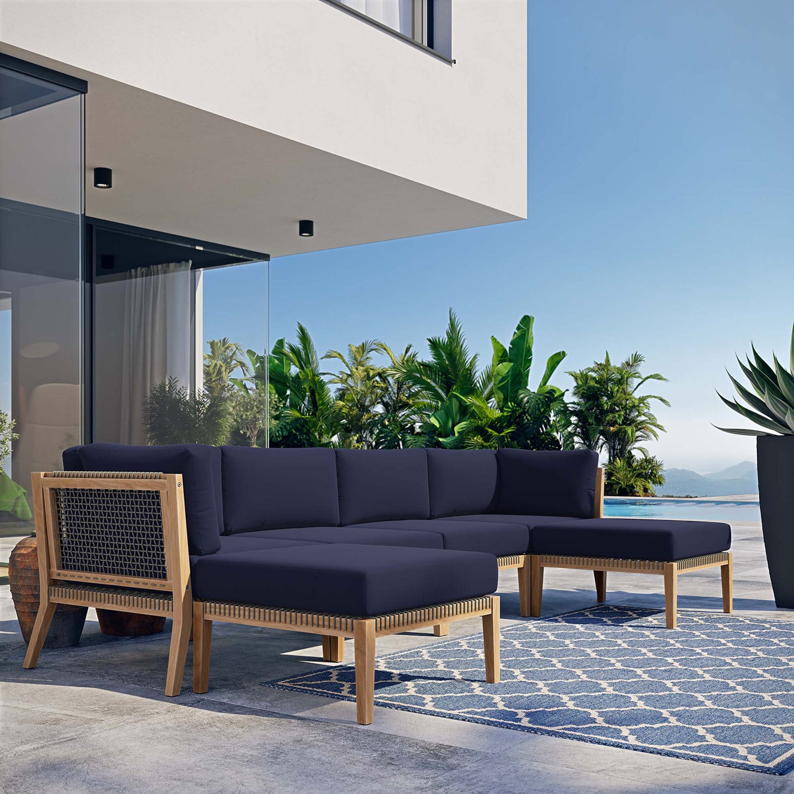 Navy blue outdoor teak sectional creating a cozy lounge area on a sunlit poolside terrace || EEI-6122-GRY-NAV || front_angle_room