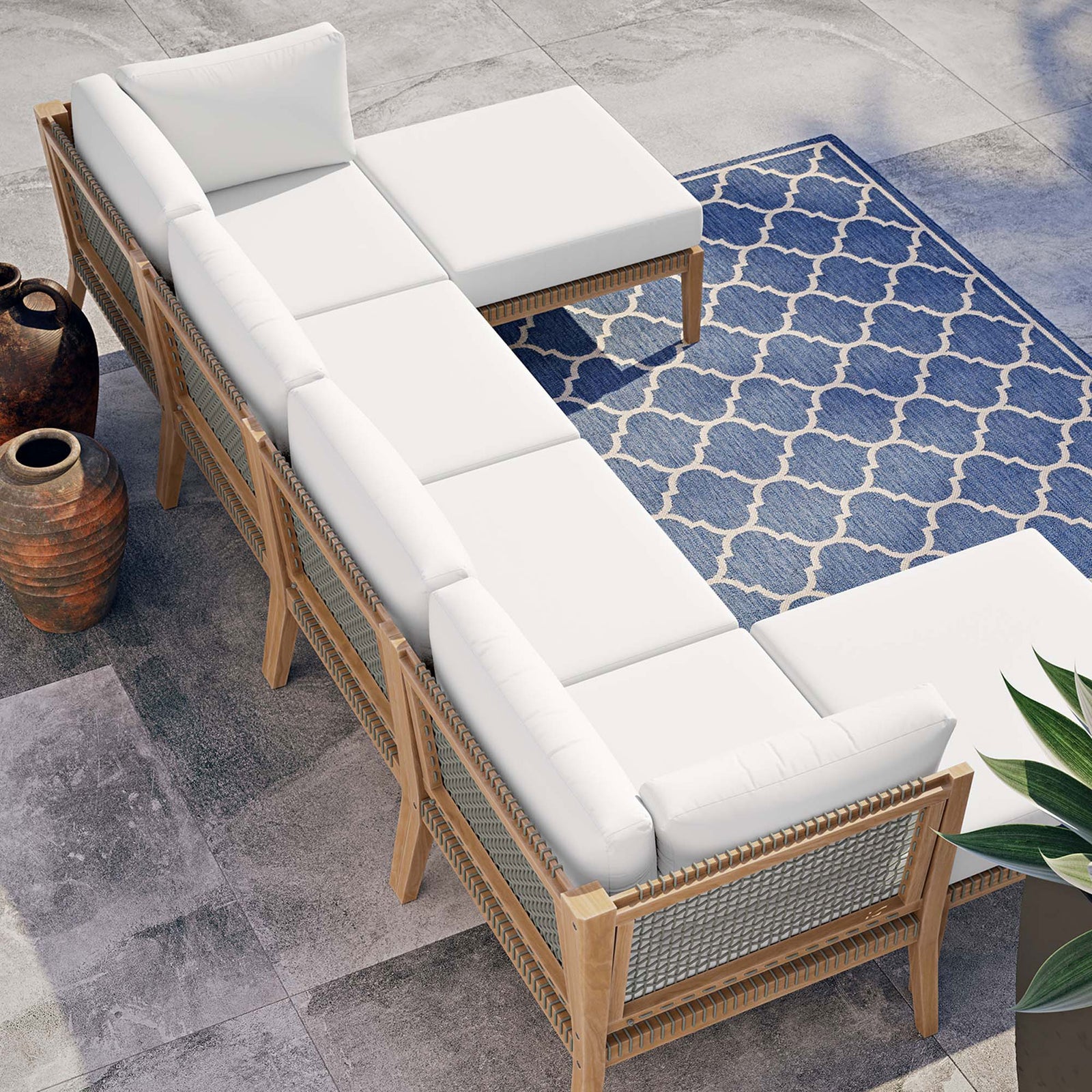 White teak sectional styled on a modern patio with blue patterned rug and planters || EEI-6122-GRY-WHI || top_angle_room