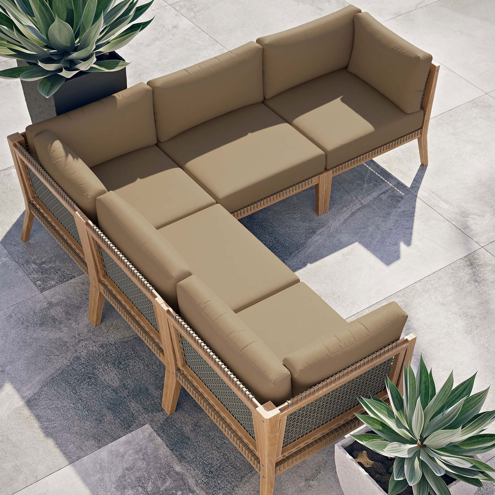 Sunny patio scene with light brown sectional arranged in an inviting L shape beside sculptural planters || EEI-6123-GRY-LBR || top_angle_room