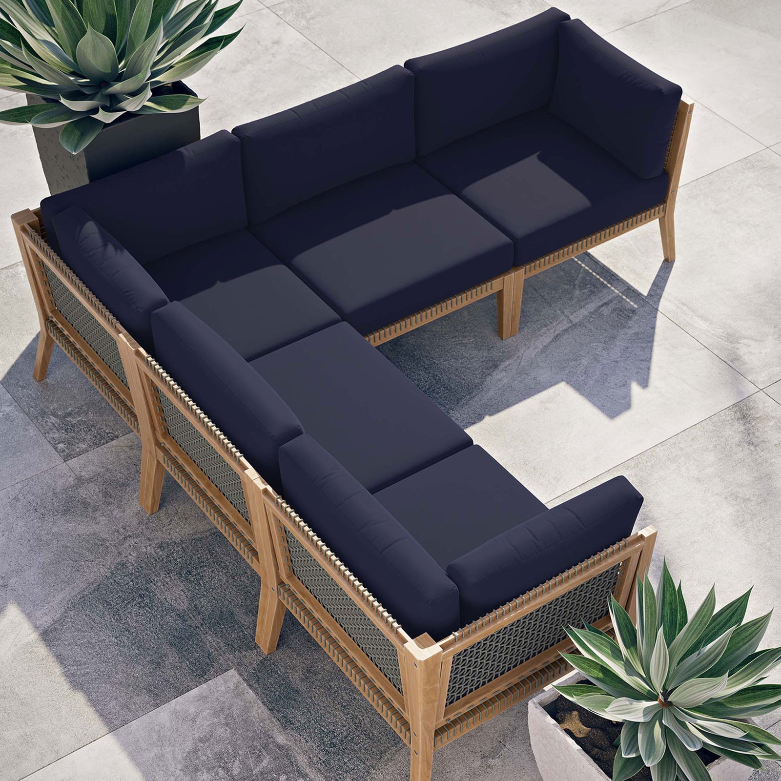 Outdoor patio layout with navy sectional forming an L shape surrounded by architectural planters || EEI-6123-GRY-NAV || top_angle_room