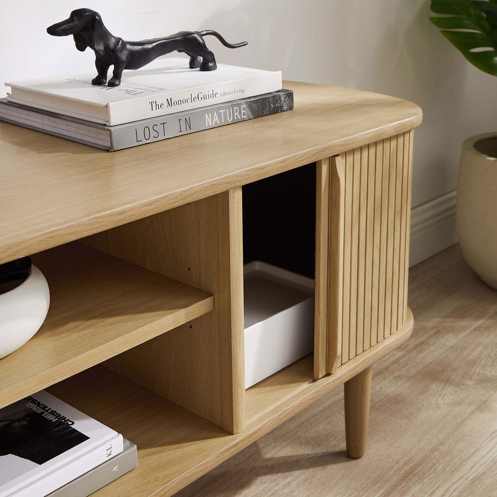 Sliding door glides open to reveal hidden storage inside the oak TV stand || EEI-6158-OAK || storage_open_room